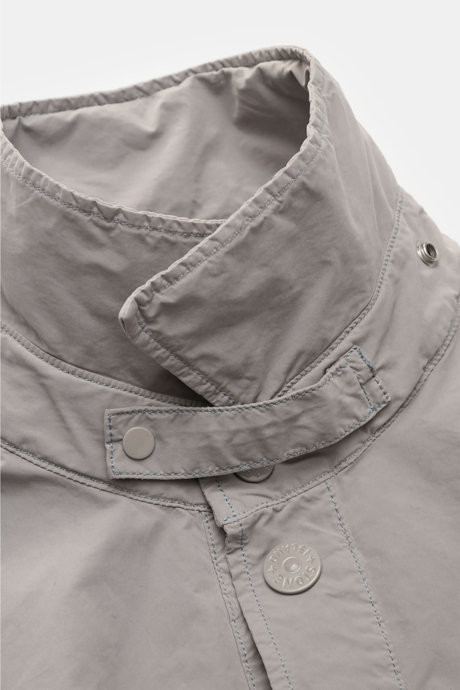 Stone Island Jacket 'Ghost Piece' light grey close-up from above showing high-quality microfibre collar with snap button placket. Urban essential: This STONE ISLAND jacket from the 'Ghost Collection' impresses with its casual design and high-quality micro