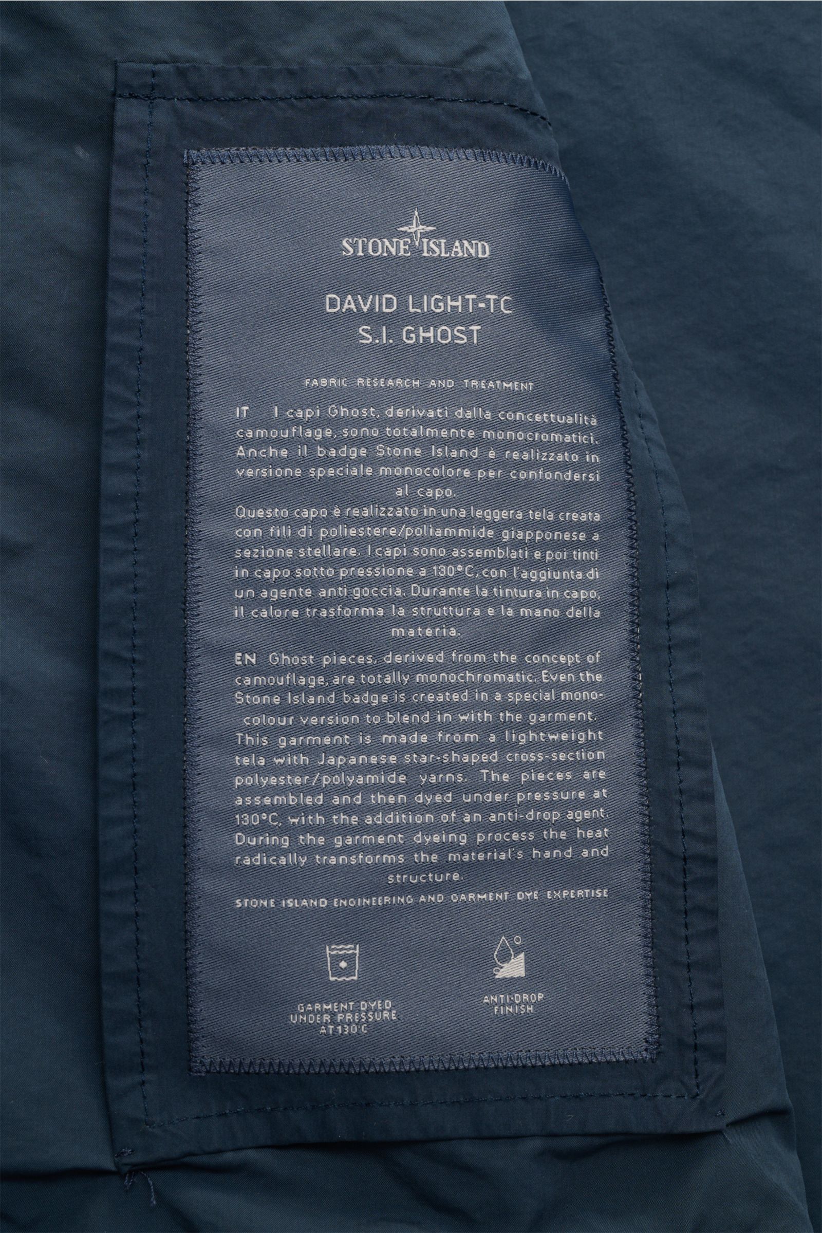 Stone Island Jacke 'Ghost Piece' dunkelblau, Detailaufnahme des Innenlabels mit Infos zu Microfaser, Slim Fit, Druckknöpfen und tonalem Badge.