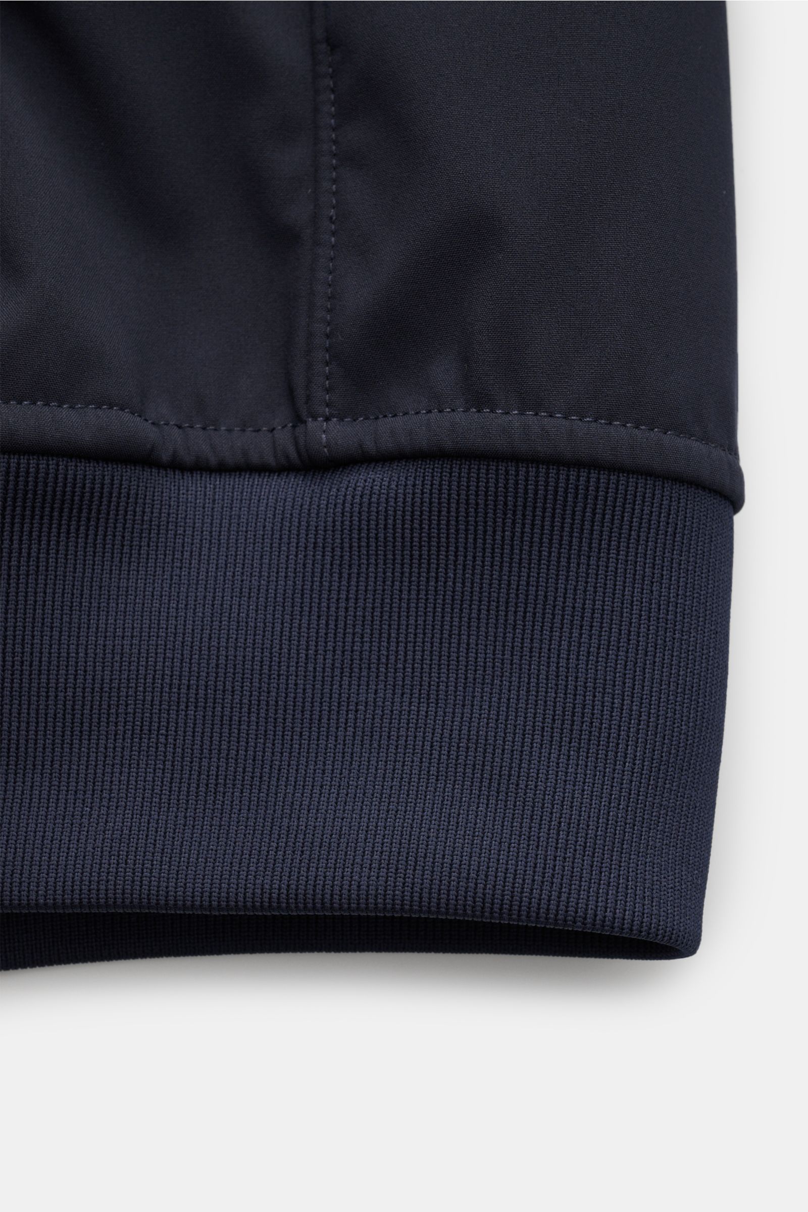 Nahaufnahme des Saum- und Ärmelbündchens des Stone Island Blouson 'Light Soft Shell-R' navy aus hochwertiger, wind- und wasserabweisender Microfaser mit glattem Griff.