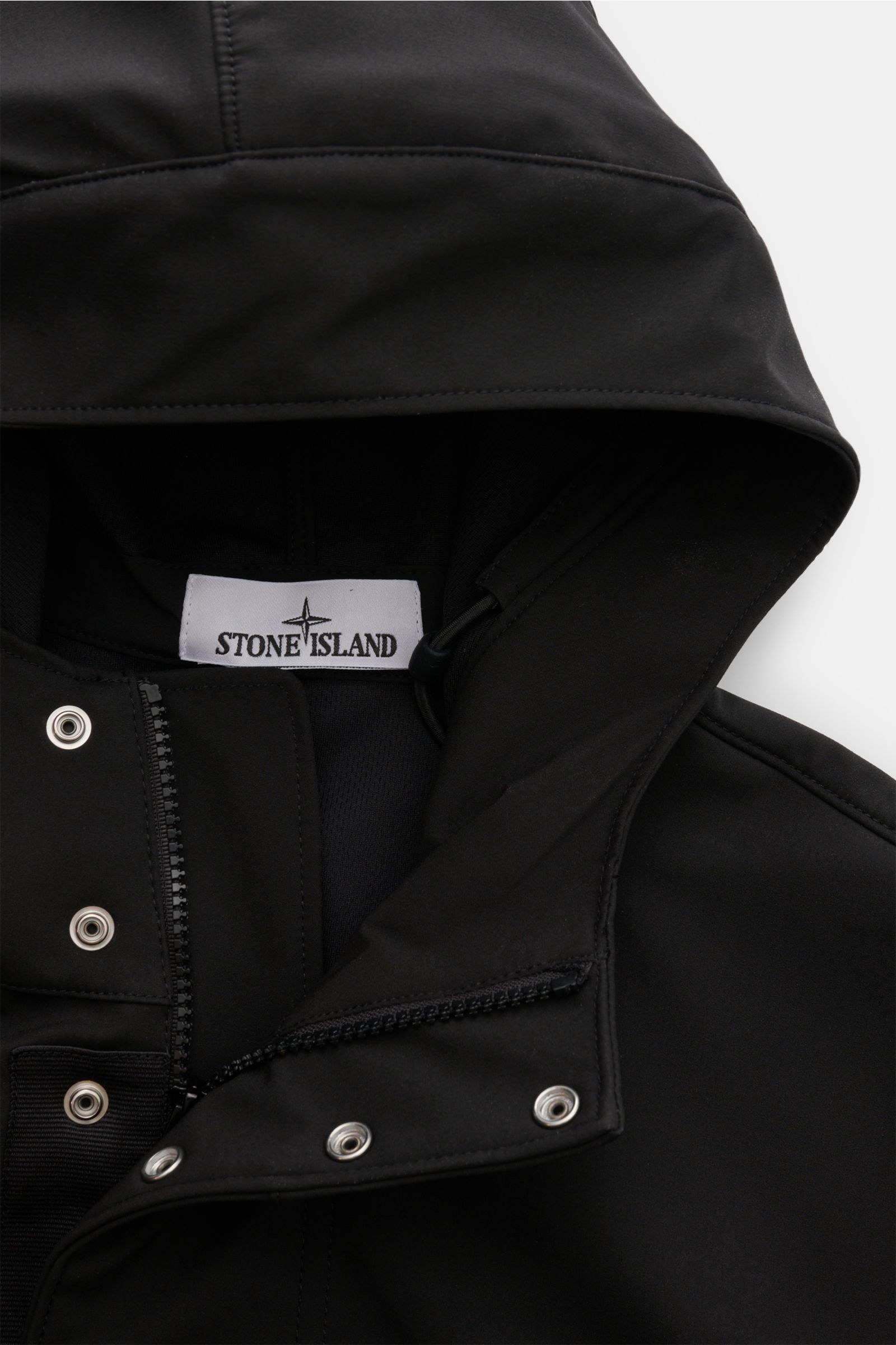 Alt-Tag (124 Zeichen): Nahaufnahme des Stone Island Blouson 'Light Soft Shell-R' schwarz, Kapuze, Tunnelzug, Zipper und Druckknöpfe sichtbar.