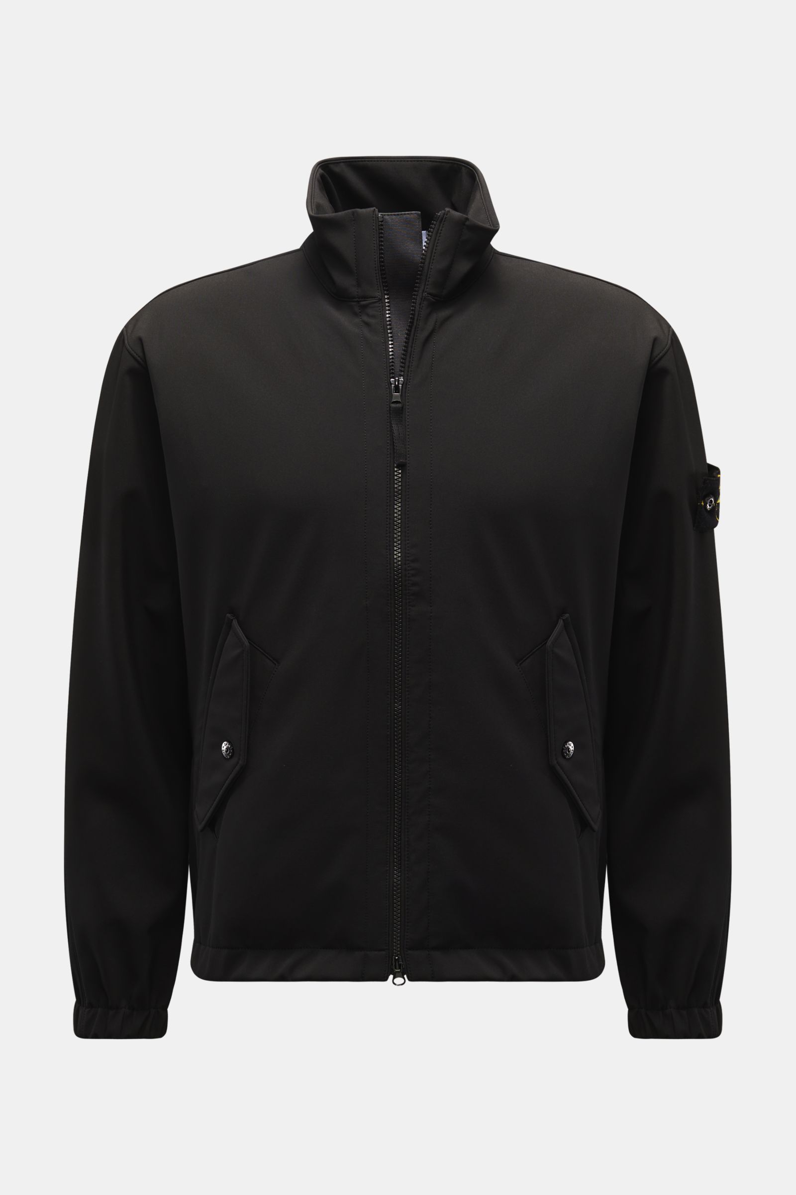 Front view of Stone Island Jacke 'Light Soft Shell-R' schwarz, a slim fit black soft shell jacket with stand-up collar, two-way zipper, flap front pockets, elastic cuffs, compass badge on upper arm, made of high-quality microfiber with smooth touch, wind-