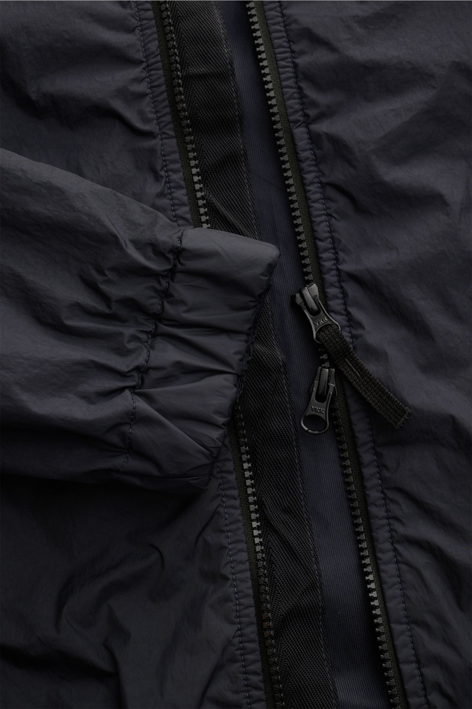 Nahaufnahme des Stone Island Blouson 'Garment Dyed Crinkle Reps NY' navy, mit Reißverschluss und elastischem Ärmelbündchen.