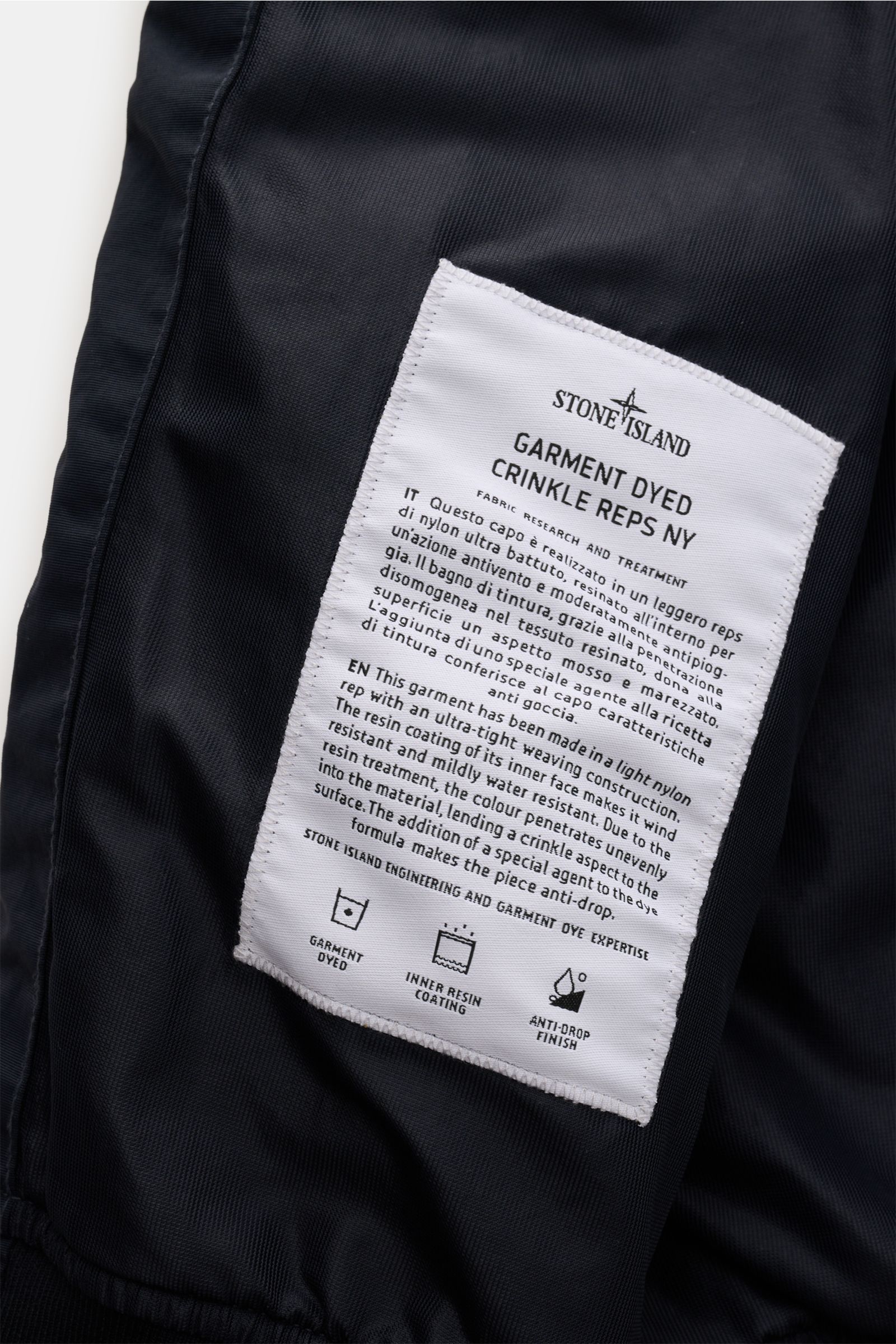 Nahaufnahme des Innenfutters mit weißem Stoffetikett des Stone Island Blouson 'Garment Dyed Crinkle Reps NY' navy aus hochwertiger Microfaser.