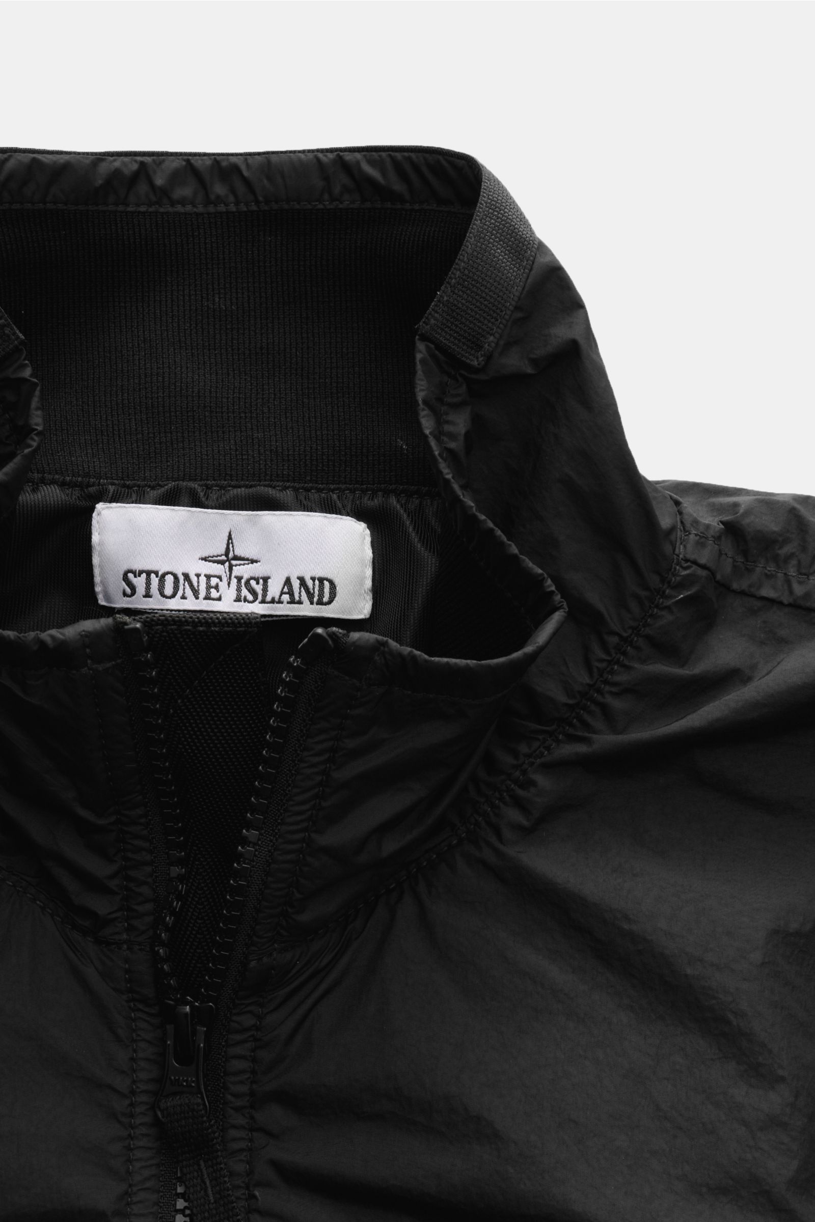 Nahaufnahme des Kragens vom Stone Island Blouson 'Garment Dyed Crinkle Reps NY' schwarz, windabweisend, Microfaser, Slim Fit.