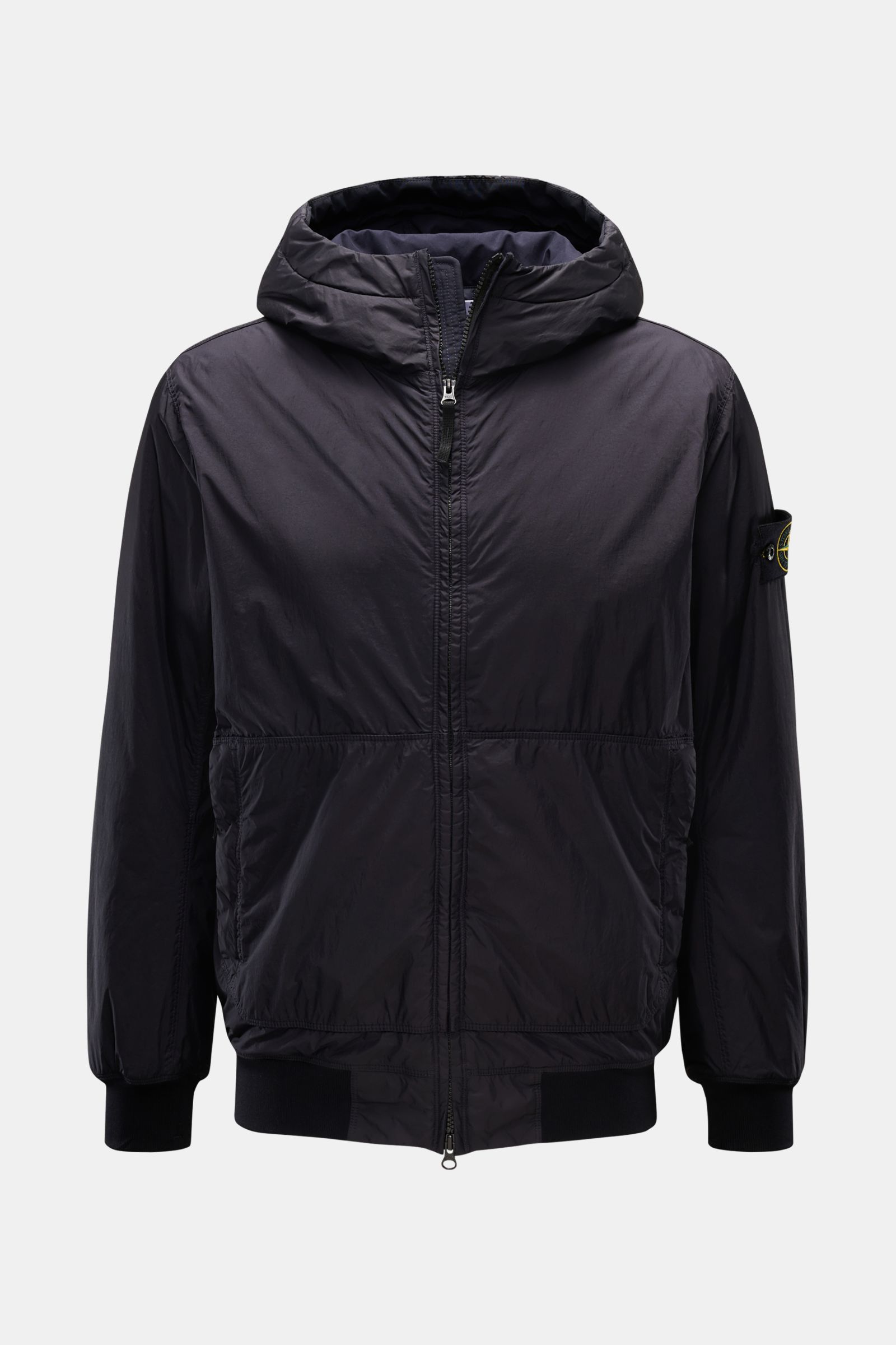 Front view of Stone Island Jacke 'Garment Dyed Crinkle Reps NY' dark navy, a lightweight, wind- and water-resistant hooded jacket with slim fit, padded hood, elastic cuffs, zipper pockets, and signature compass badge on the upper arm. Funktion trifft Styl