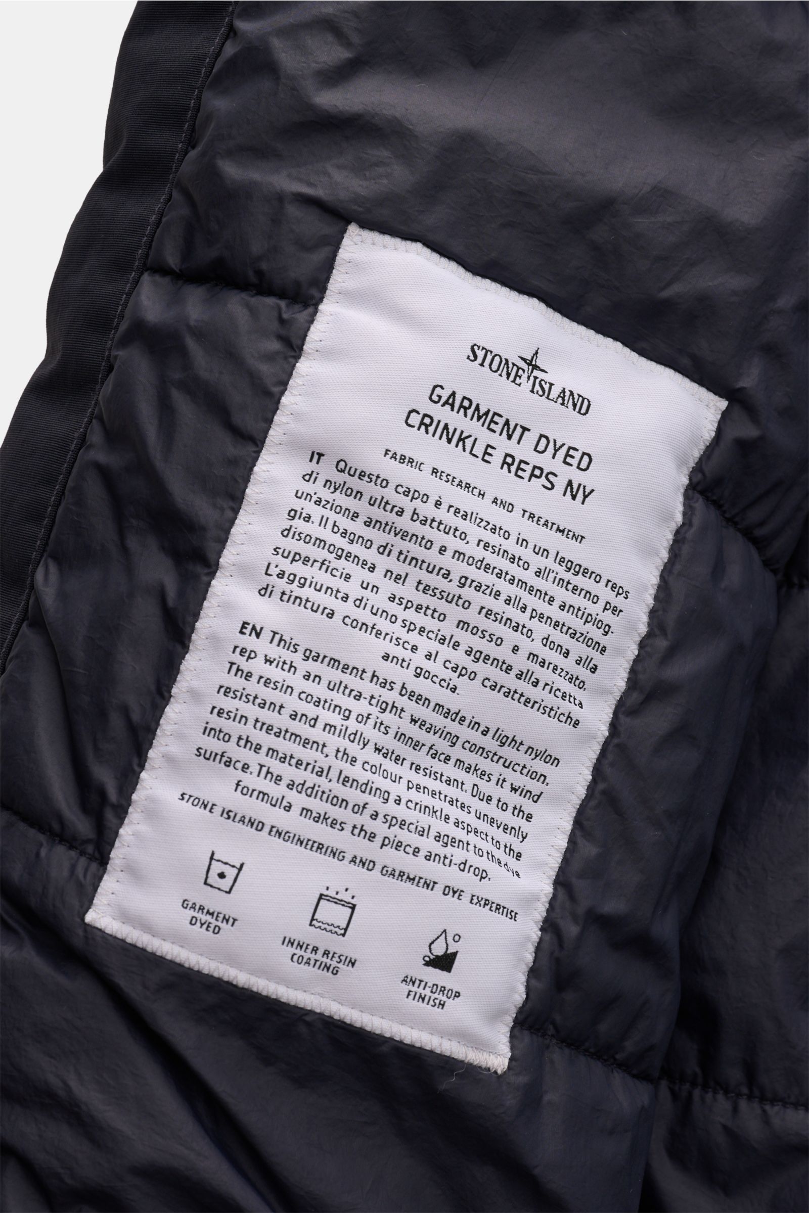 Close-up interior view of the Stone Island Jacke 'Garment Dyed Crinkle Reps NY' dark navy label sewn on lightweight, crinkled nylon fabric with resin coating. Funktion trifft Style: Die sportive Jacke von STONE ISLAND besteht aus einem leichten Microfaser