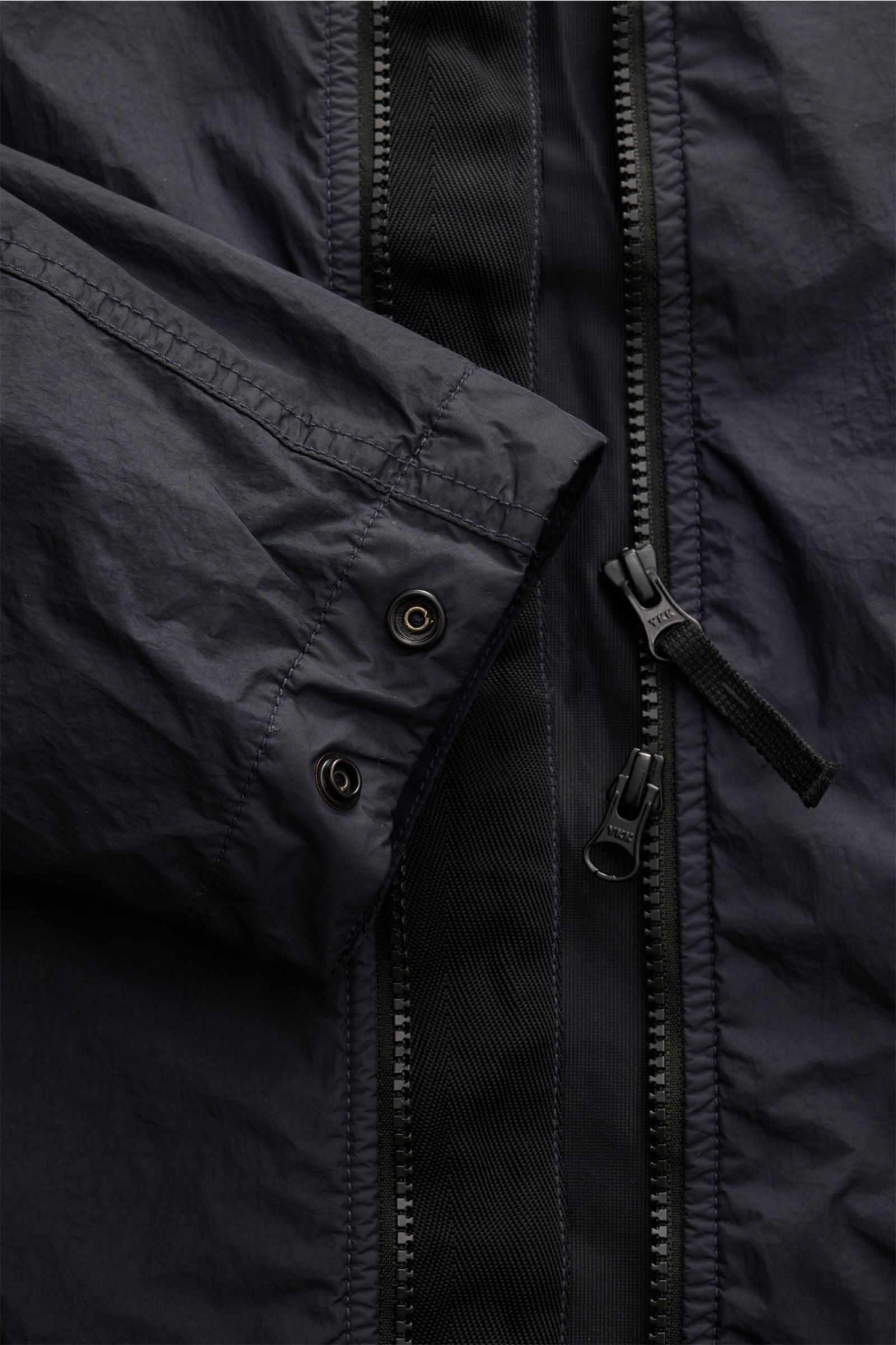 Stone Island Jacke 'Garment Dyed Crincle Reps NY' dark navy im Detail, Nahaufnahme von Ärmel mit Druckknopf und Zwei-Wege-Reißverschluss, technische Microfaser, wasserabweisend, windblockend, Slim Fit, Kapuze, Kompass-Badge, schräge Hüfttaschen, glänzende