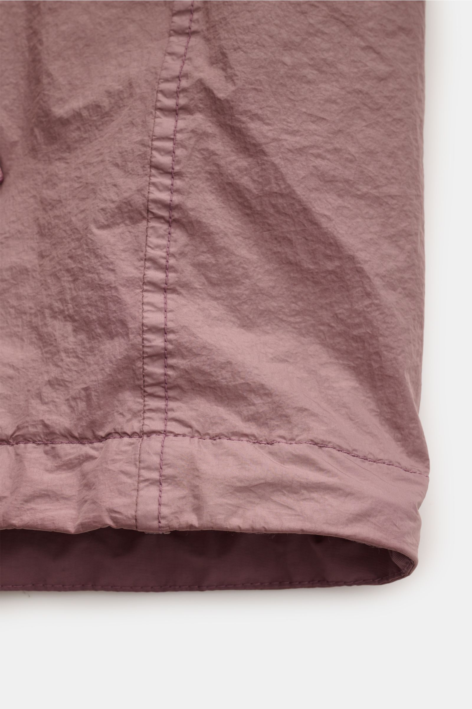 Nahaufnahme vom Saum der Stone Island Jacke 'Garment Dyed Crincle Reps NY' altrosa, ultraleicht, wasserabweisend und windblockend.