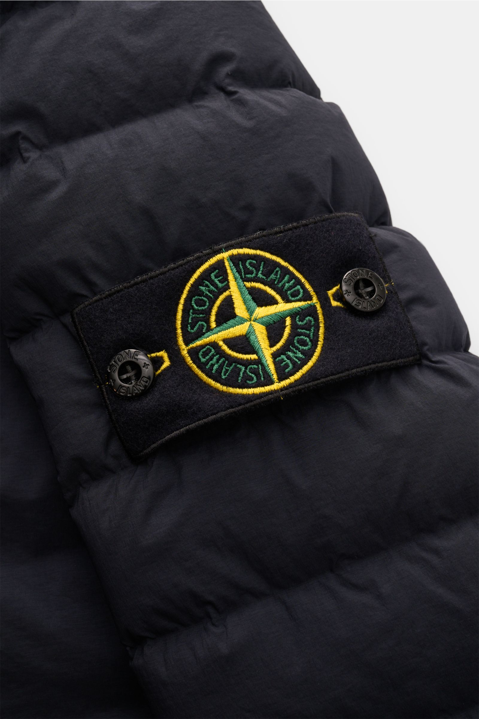 Stone Island Daunenjacke 'Seamless Tunnel Nylon Down-TC' dark navy, Nahaufnahme des typischen Kompass-Badges auf hochwertiger, wasserabweisender Microfaser mit leichter Entendaunenfüllung.