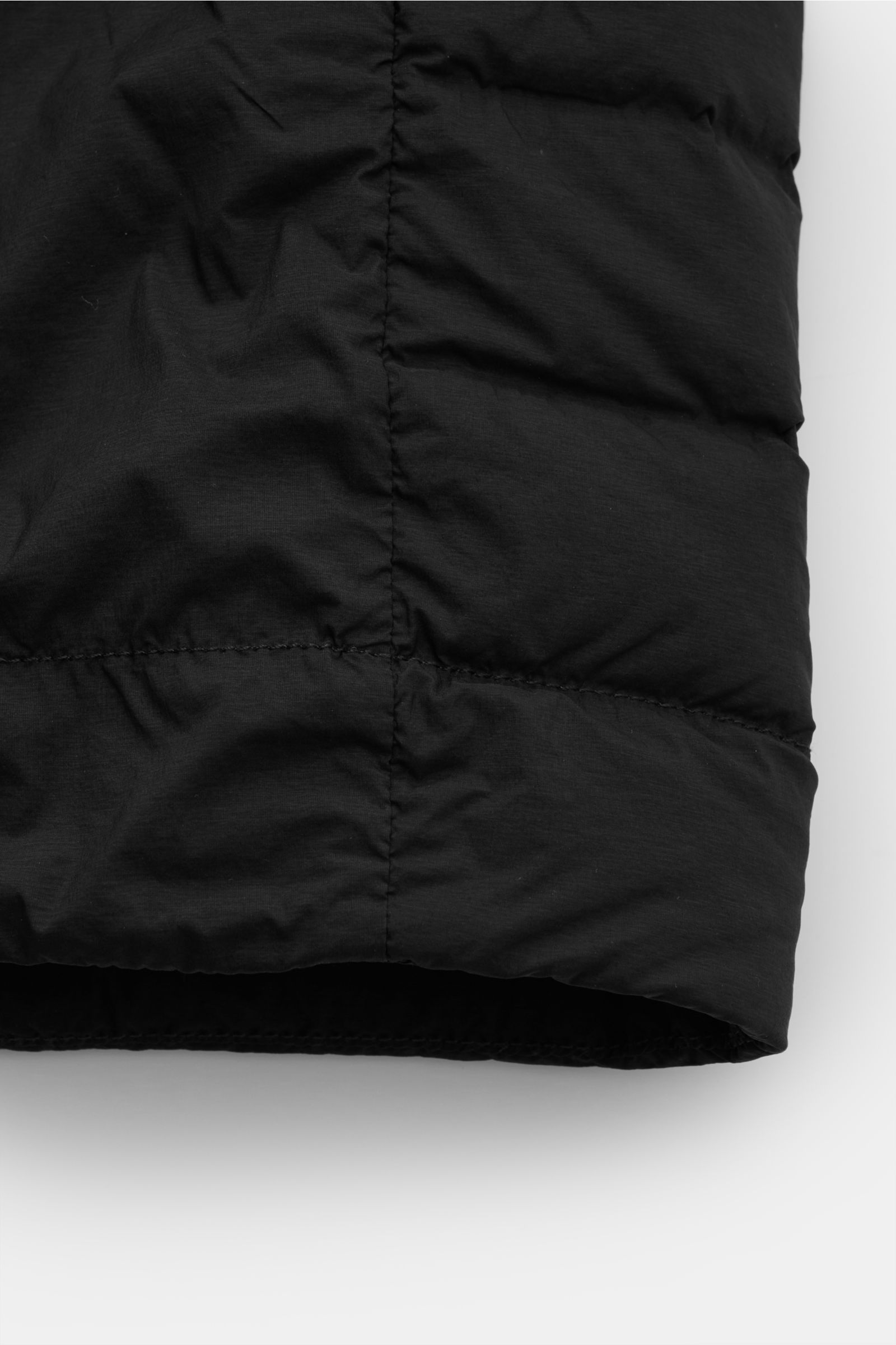 Stone Island Daunenjacke 'Seamless Tunnel Nylon Down-TC' schwarz, Detailansicht des unteren Bereichs mit hochwertiger, wasserabweisender Microfaser und leichter Entendaunenfüllung.