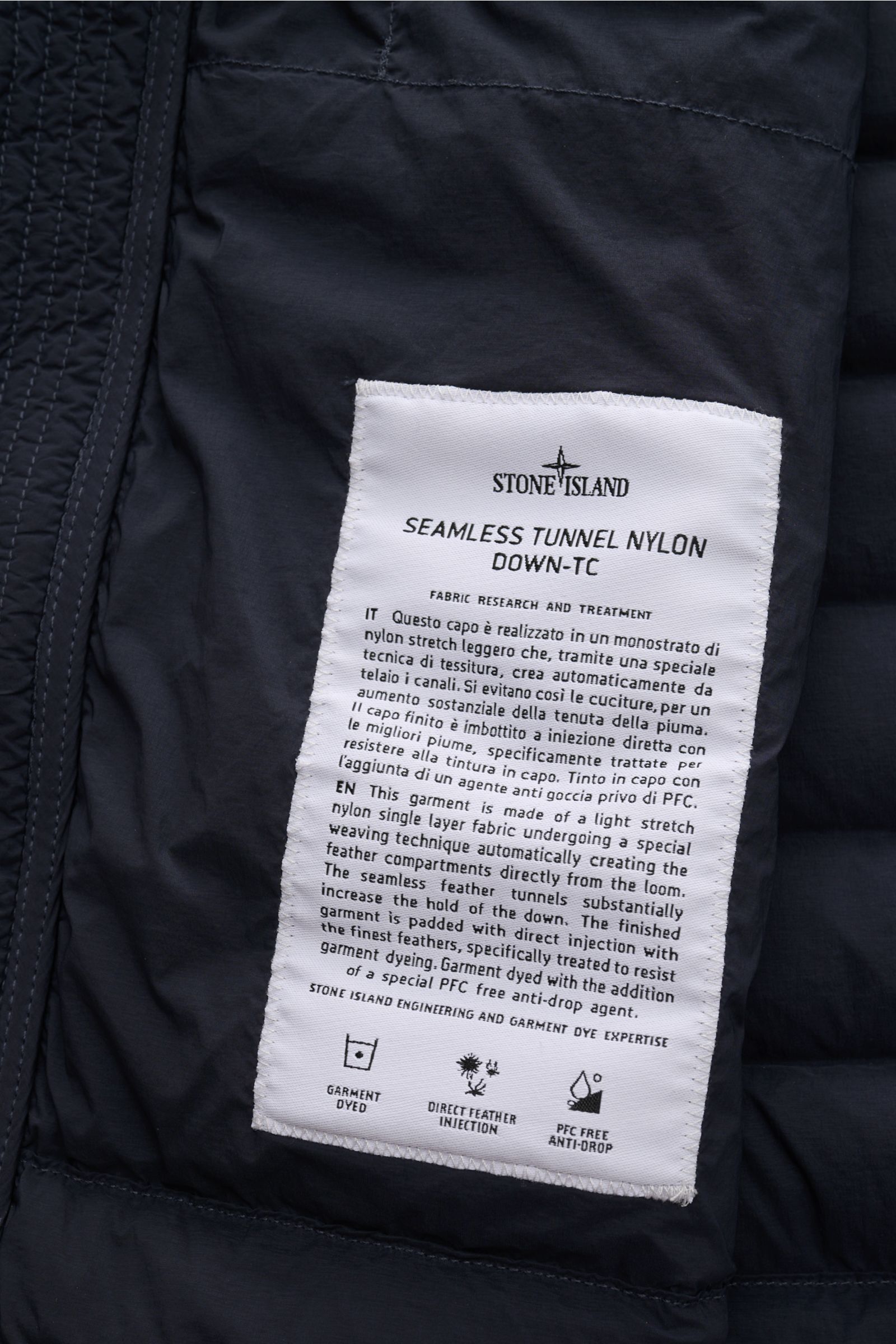 Stone Island Daunenjacke 'Seamless Tunnel Nylon Down-TC' dark navy, Nahaufnahme des innenliegenden Labels mit Material- und Pflegehinweisen.