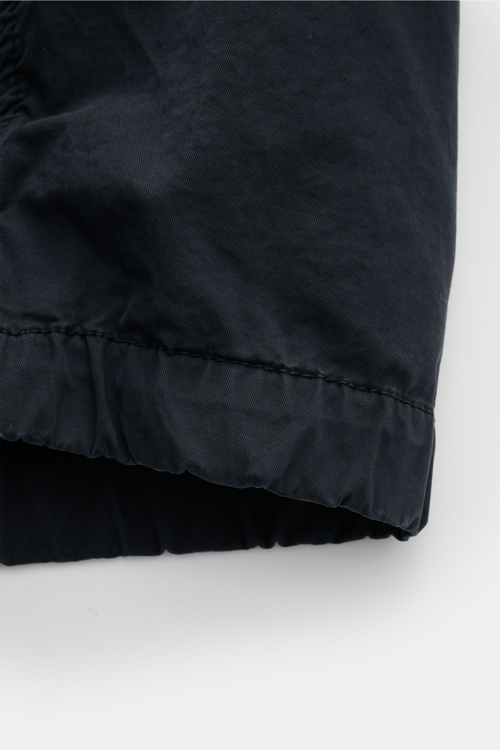 Close-up front view of the elastic hem on the Stone Island Blouson 'Stretch Cotton Twill-TC' navy, made of soft, elastic cotton. Sportives Frühlings-Essential: Mit seinem leichten Baumwollmaterial wird der STONE ISLAND Blouson zum idealen Begleiter an wär