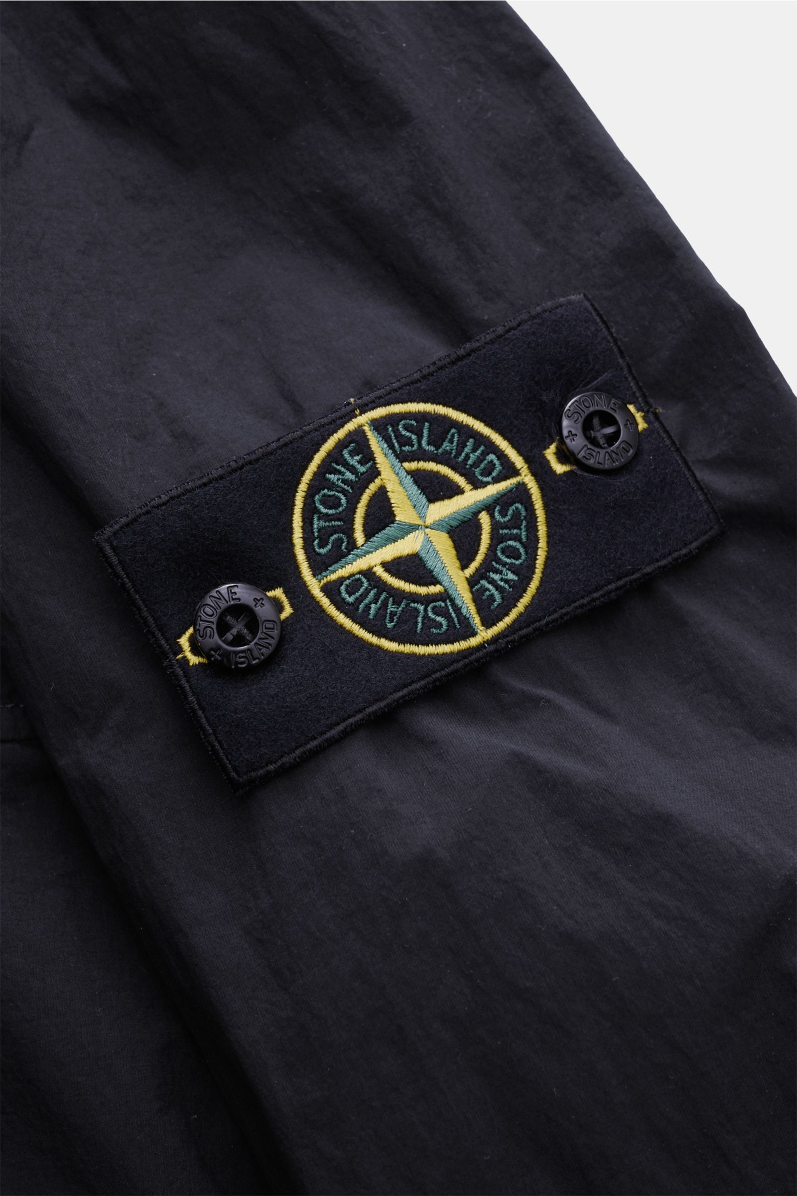 Stone Island Jacke 'Nylon Smerigliato-TC' navy, Detailansicht des ikonischen Kompass-Badge auf hochwertiger, wasserabweisender Microfaser.