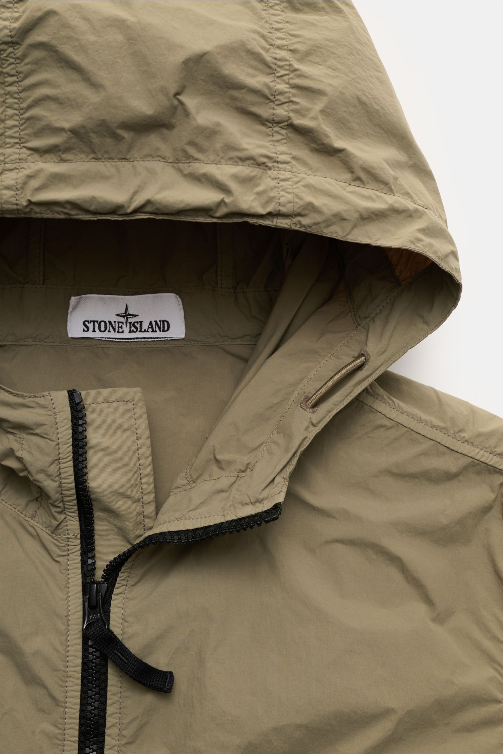 Stone Island Jacke 'Nylon Smerigliato-TC' oliv, Kapuze, Zwei-Wege-Reißverschluss, detailnah von oben, wasserabweisend, leicht, Slim Fit.