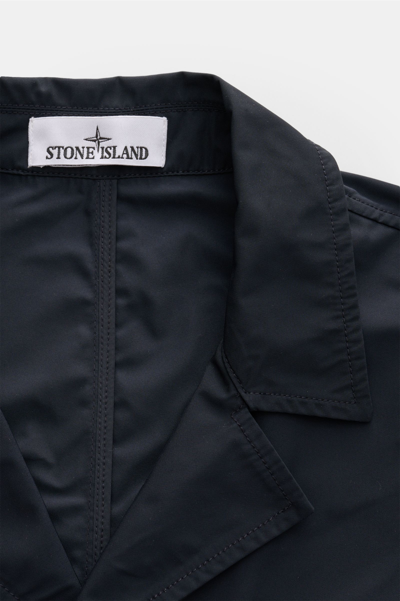 Nahaufnahme der Stone Island Jacke 'Micro Twill' navy von oben, zeigt das fallende Revers und das glatte Micro-Twill-Material.