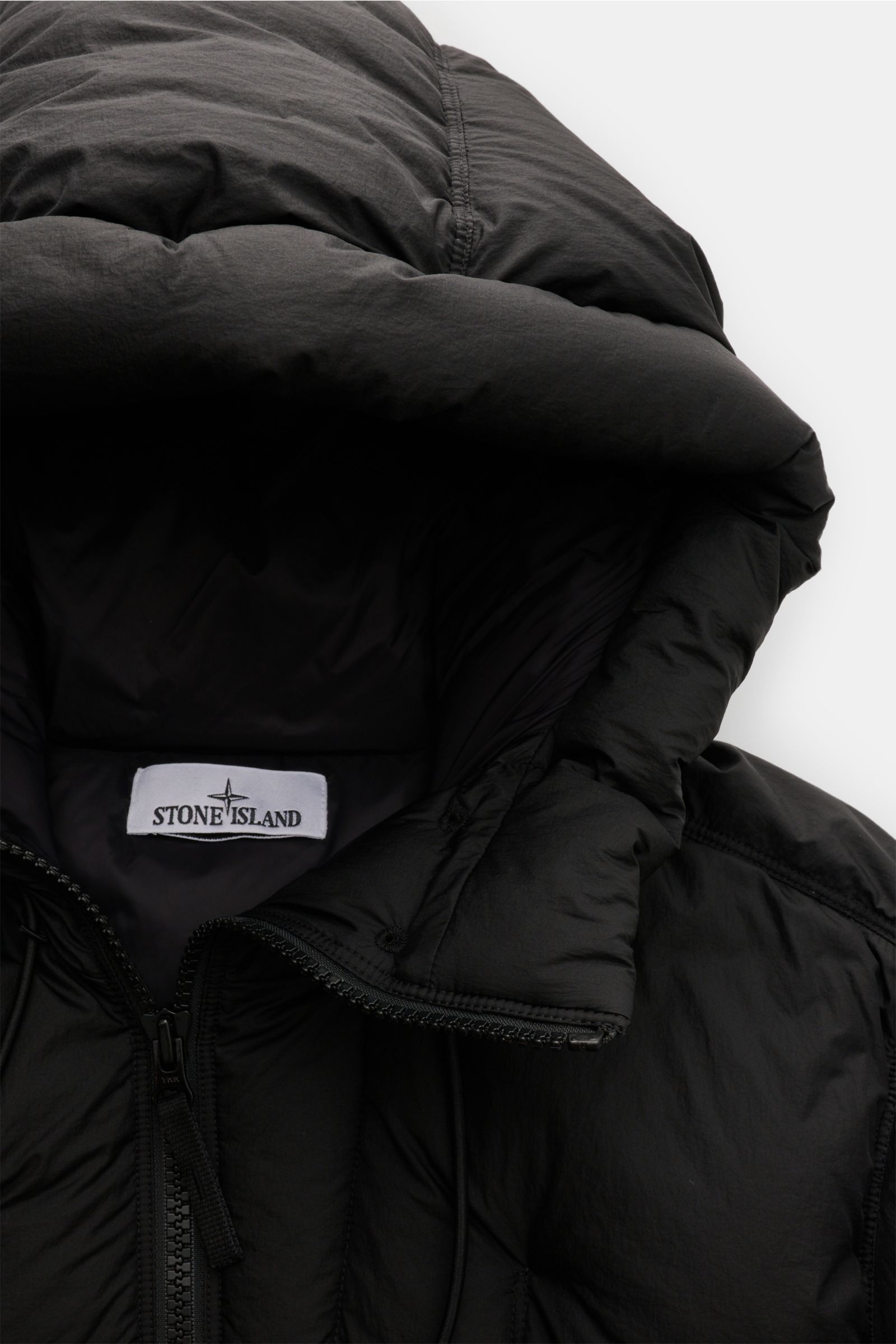 Close-up front view of Stone Island Down jacket 'Seam Faded Light Nylon Tela' black, showing padded hood, high-quality microfibre, smooth feel, and warm down lining.