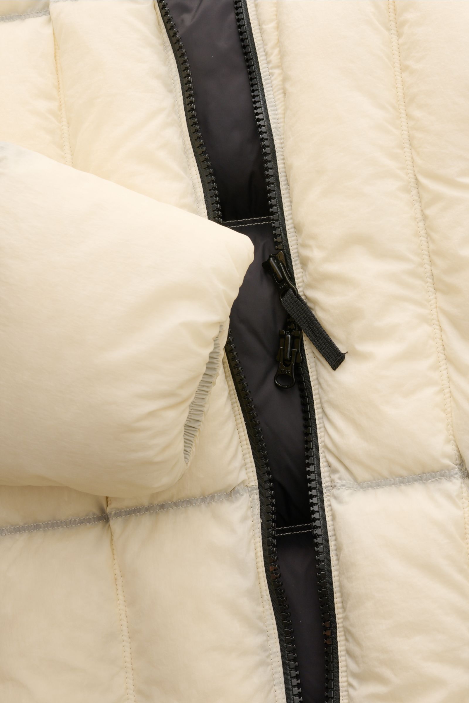 Alt-Tag (124 Zeichen):

Nahaufnahme der offwhite Stone Island Daunenjacke 'Seam Faded Light Nylon Tela' mit schwarzem Zwei-Wege-Reißverschluss und elastischem Ärmel.