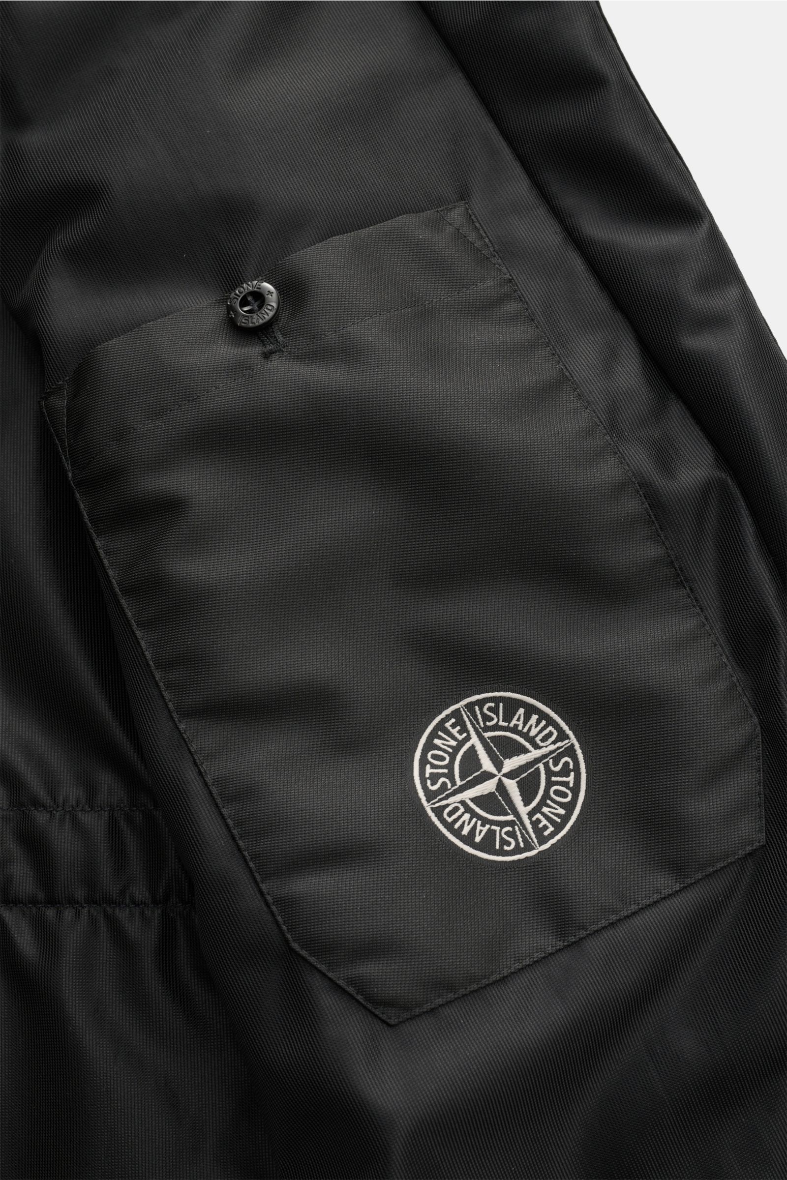 Close-up detail from the inside of the Stone Island Blouson 'Light Ripstop Cordura' black showing the high-strength ripstop fabric pocket with button and embroidered logo, highlighting robust yet lightweight microfibre construction, smooth feel, and durab