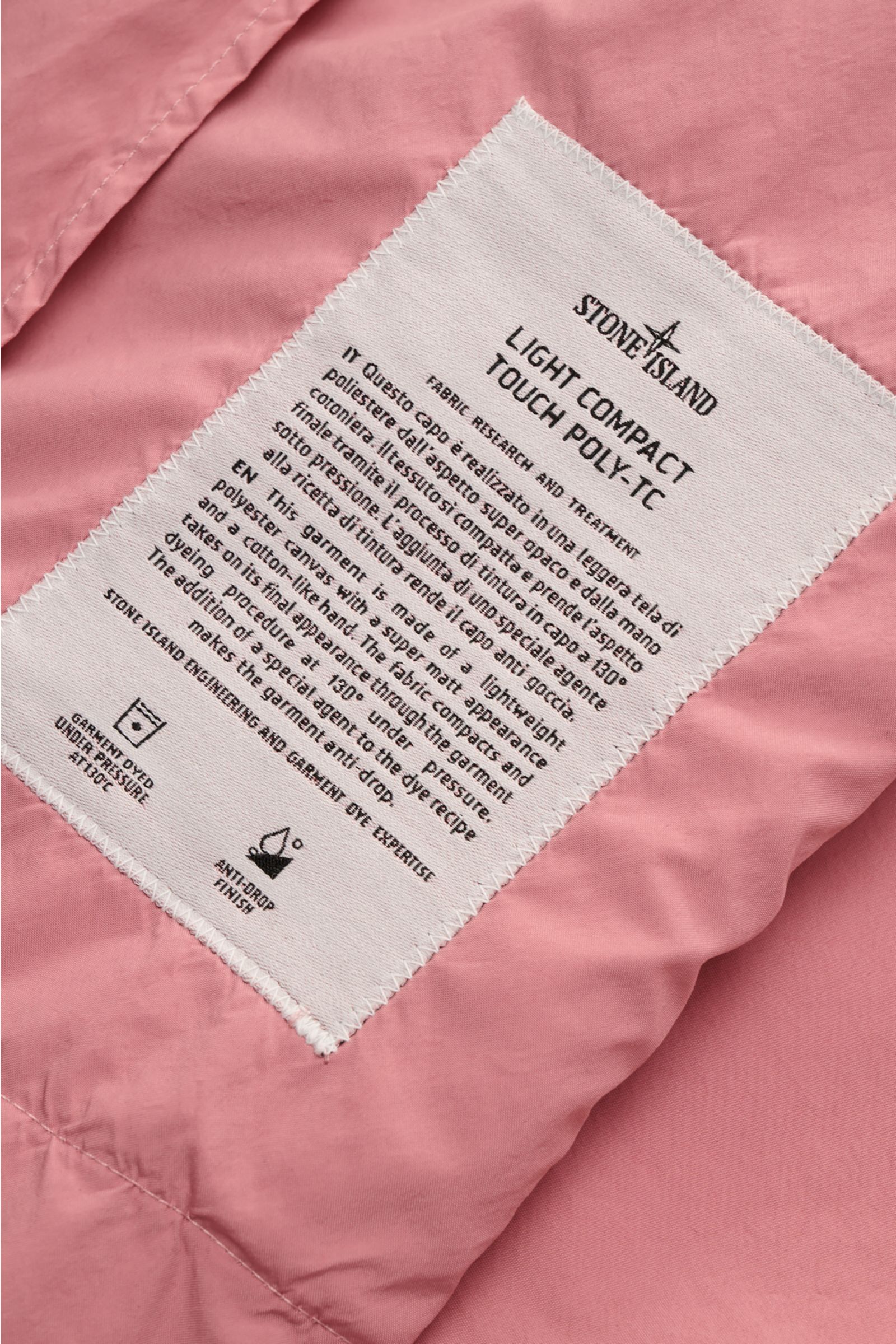 Close-up from above of the inside label on the Stone Island Jacket 'Light Compact Touch Poly-TC' antique pink, showing fabric details. Made for changeable days: The lightweight, water repellent jacket 'Light Compact Touch Poly-TC' by STONE ISLAND in a sty