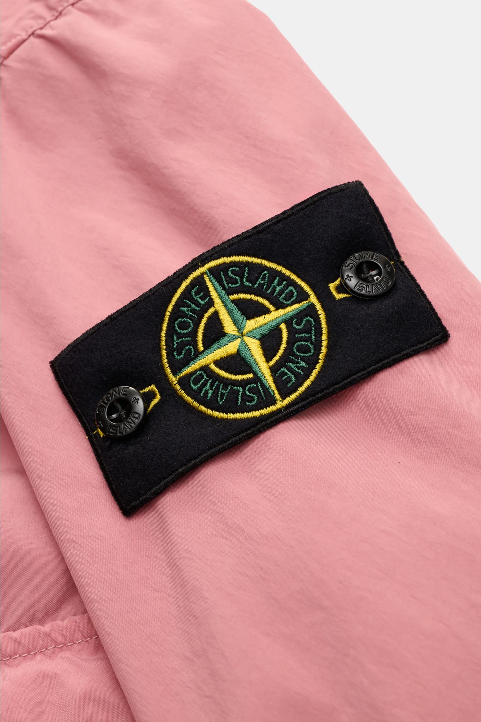 Stone Island Jacket 'Light Compact Touch Poly-TC' antique pink shown in close-up from the sleeve perspective, featuring the signature compass badge on stretchy, water repellent microfibre fabric with a light velvety feel. Made for changeable days: The lig