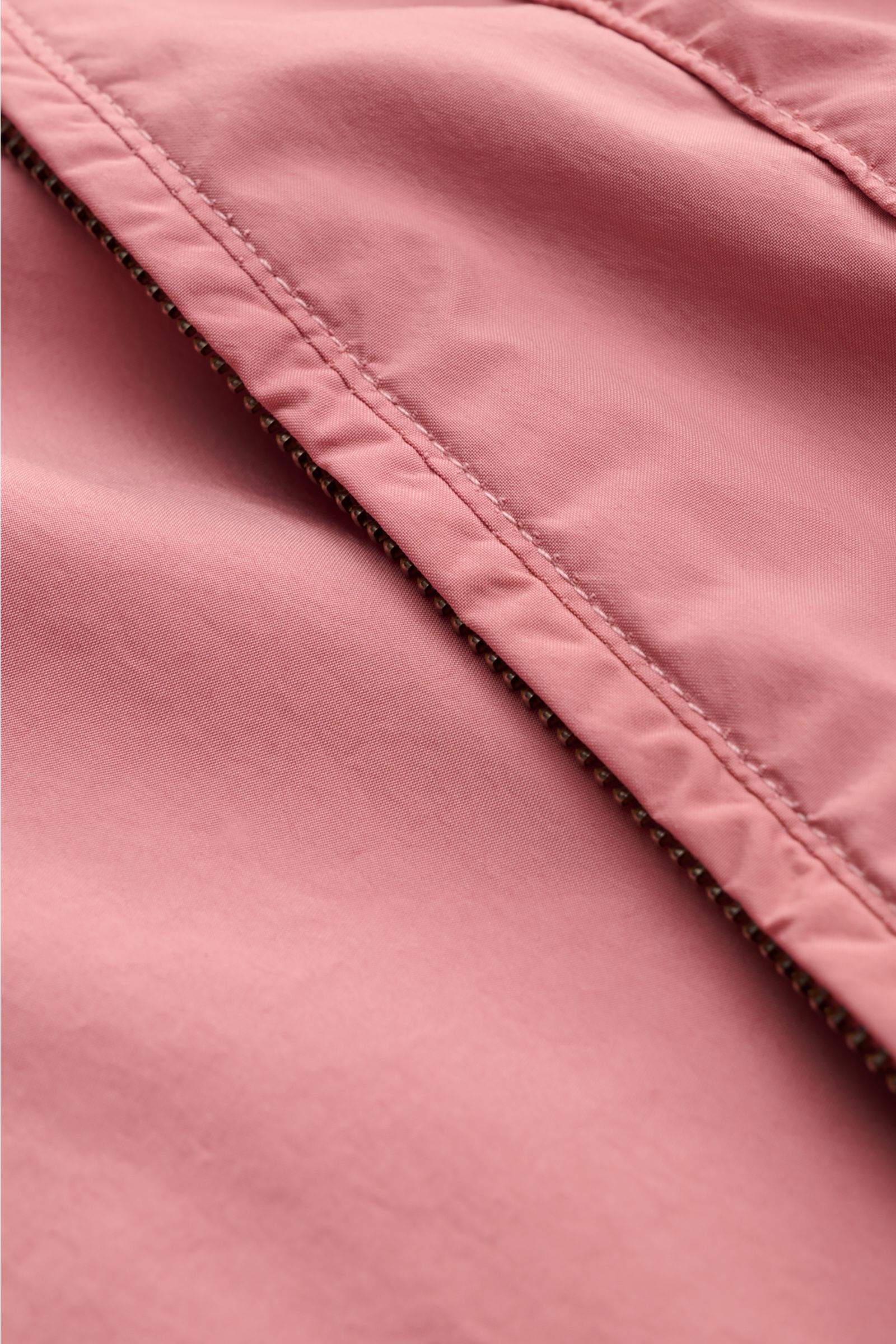 Close-up front perspective of Stone Island Jacket 'Light Compact Touch Poly-TC' antique pink, showing water repellent stretchy microfiber fabric with visible zipper stitching. Made for changeable days: The lightweight, water repellent jacket 'Light Compac