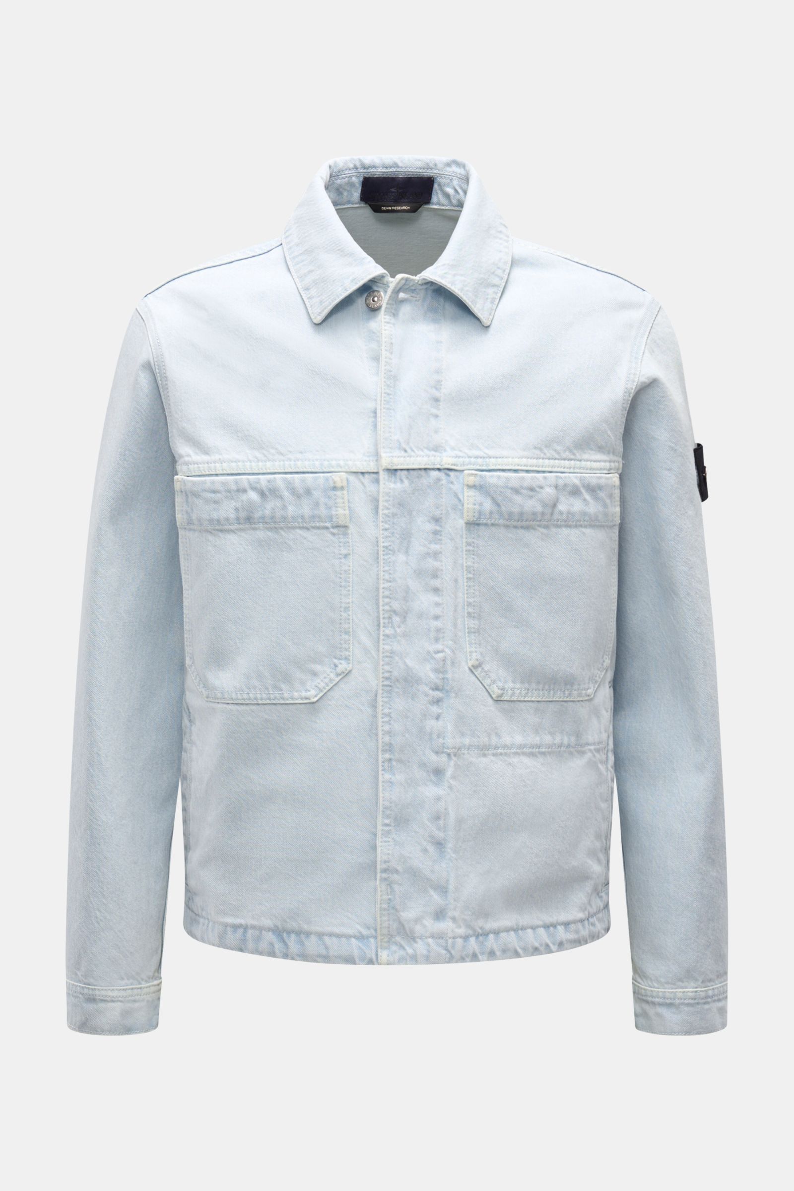 Front view of Stone Island Denim jacket pastel blue in slim fit, featuring pure cotton denim, patch front pockets, concealed button placket, turn-down collar, four front pockets, cuffs with button, and compass badge on upper sleeve. A timeless companion f