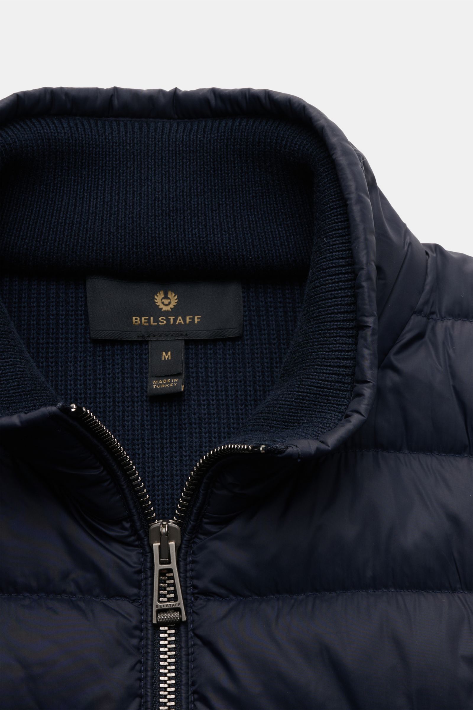 Close-up front view of Belstaff Daunenjacke 'Control Cardigan' navy showing microfiber down-filled quilted front, wool knit collar, two-way zipper, and ribbed cuffs. Der Hybrid 'Control Cardigan' der Bikermarke BELSTAFF ist eine coole Übergangsjacke mi