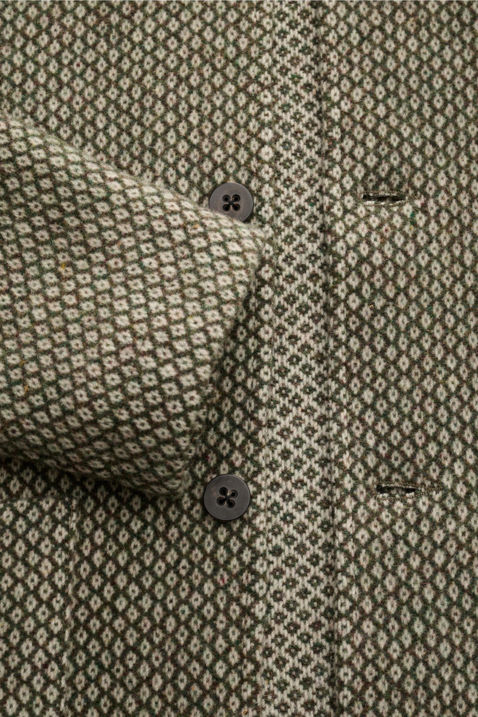 Nahaufnahme der 04651/ A trip in a bag Wolljacke grün/creme gemustert, Slim Fit, Strick aus reiner Wolle, feines Strickmuster, Fünf-Knopf-Leiste, Umlegekragen, aufgesetzte Hüfttaschen, eine Innentasche, ungefüttert, leicht griffige Qualität, von vorne fot