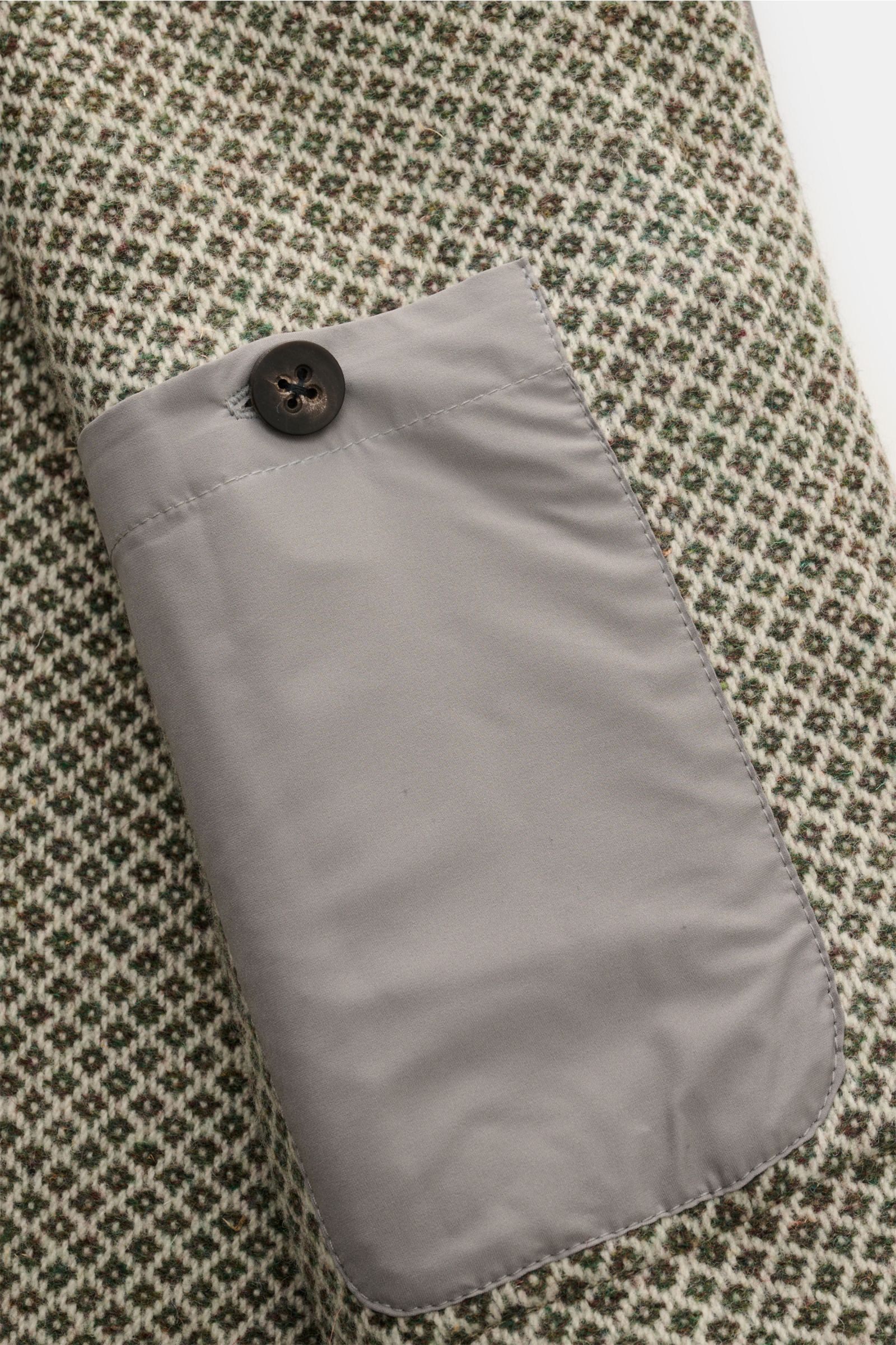 Nahaufnahme der Innentasche mit Knopf der 04651/ A trip in a bag Wolljacke grün/creme gemustert aus feinem Strickmuster, reiner Wolle, Slim Fit, ungefüttert.