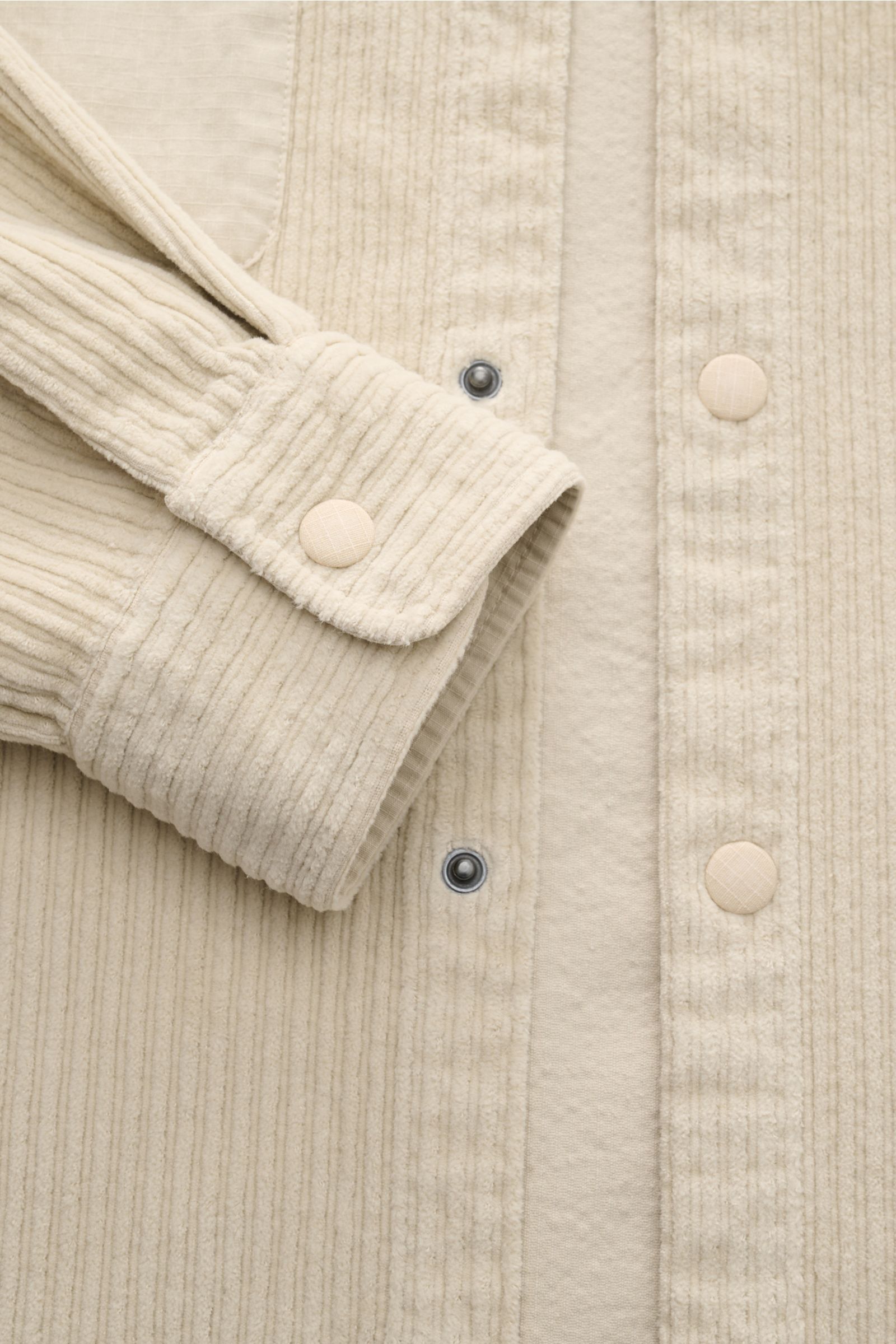 Nahaufnahme von Ärmel und Knopfleiste des 04651/ A trip in a bag Cord-Overshirt sand aus leicht elastischem Baumwoll-Cord.