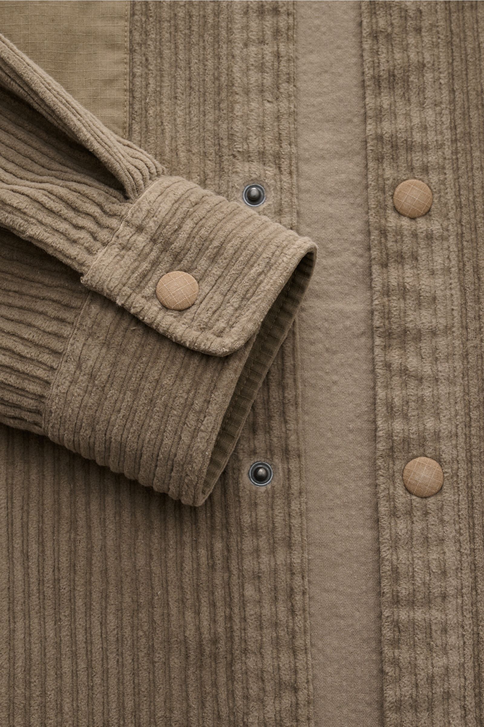 04651/ A trip in a bag Cord-Overshirt taupe, Nahaufnahme von Ärmel und Druckknopfleiste aus leicht elastischem Baumwoll-Cord in Regular Fit.