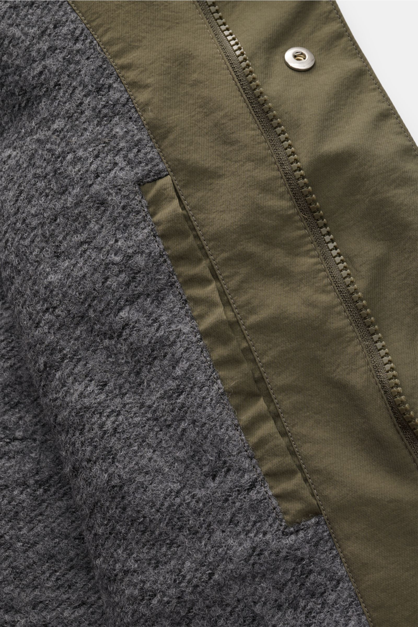 Nahaufnahme des innenliegenden grauen Futterstoffs und des Reißverschlusses des 04651/ A trip in a bag Parka 'The Coat' oliv mit hochwertiger Microfaser.