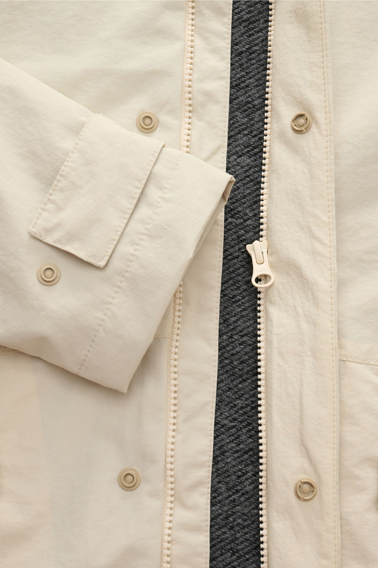 Nahaufnahme der 04651/ A trip in a bag Jacke sand aus hochwertiger Microfaser mit glattem Griff, Reißverschluss, Druckknopf am Ärmel und Woll-Mix Innenfutter.