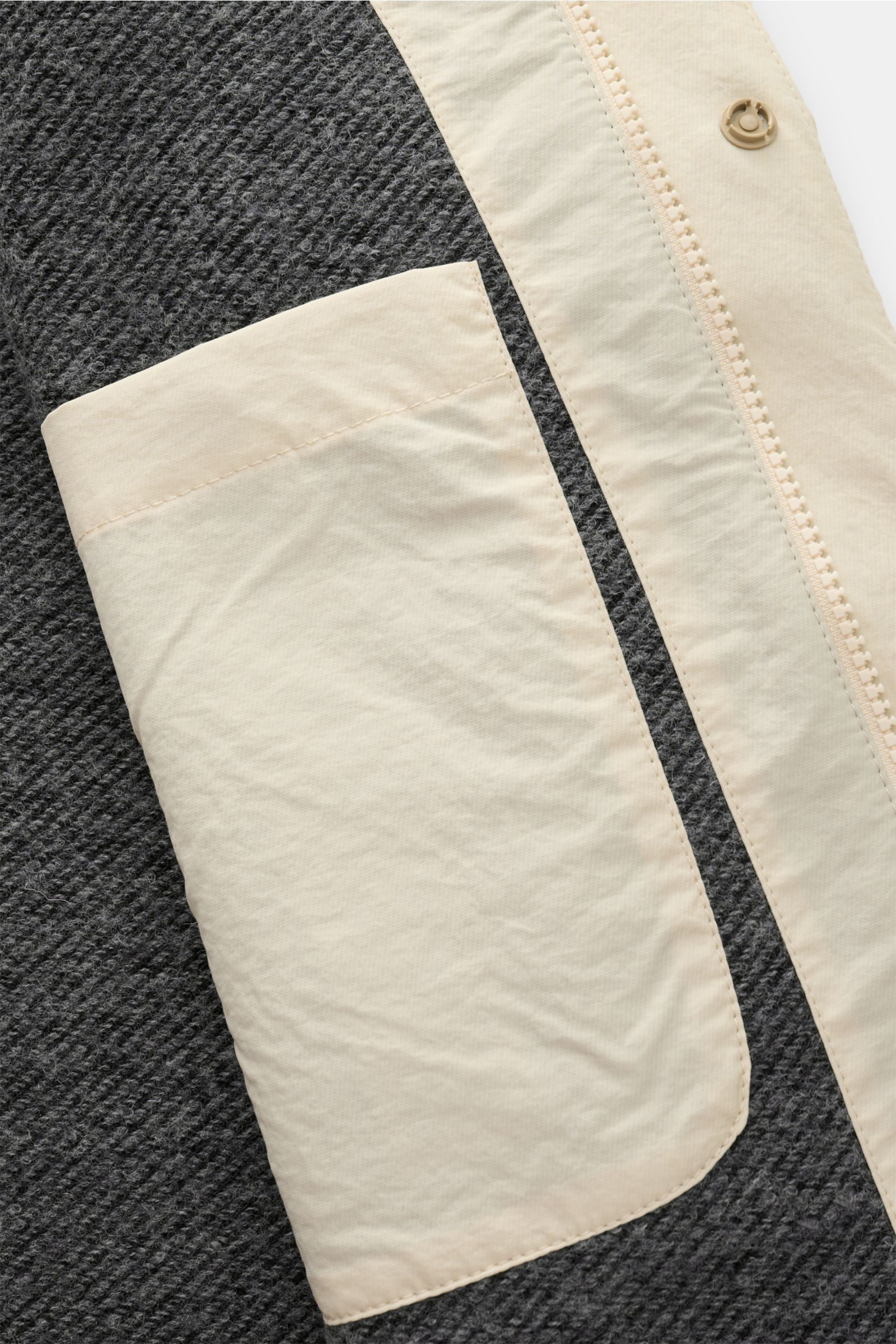 Nahaufnahme der Innentasche und Reißverschluss der 04651/ A trip in a bag Jacke sand aus hochwertiger Microfaser mit glattem Griff, leichter Wattierung, wind- und wasserabweisend, Regular Fit, versteckter Kapuze, Raglanärmeln, Hüfttaschen mit Patte, klein