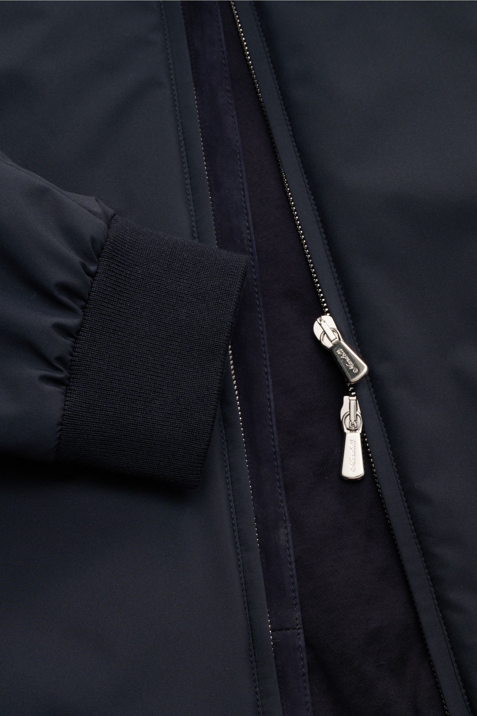 Close-up front view of the Mandelli Blouson navy showing smooth microfiber fabric, ribbed cuff, and concealed two-way zipper, with soft cotton-jersey lining. Der wattierte Blouson von MANDELLI interpretiert einen Klassiker mit souveräner Leichtigkeit neu: