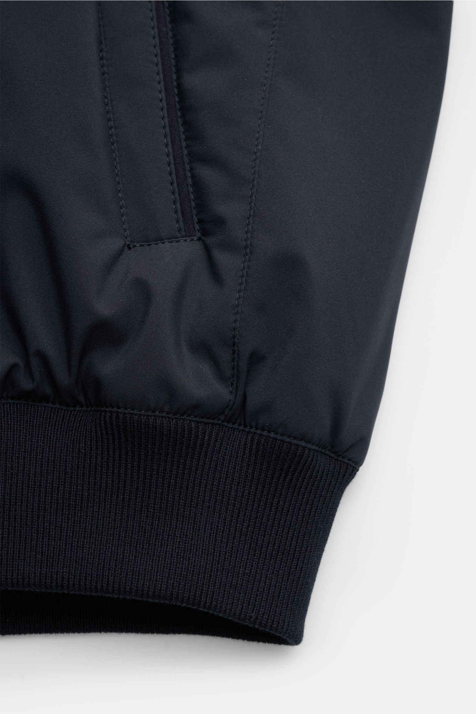 Nahaufnahme des Ärmelbundes mit Rippbündchen und schräger Leistentasche des Mandelli Blouson navy aus glatter Microfaser, leicht wattiert.