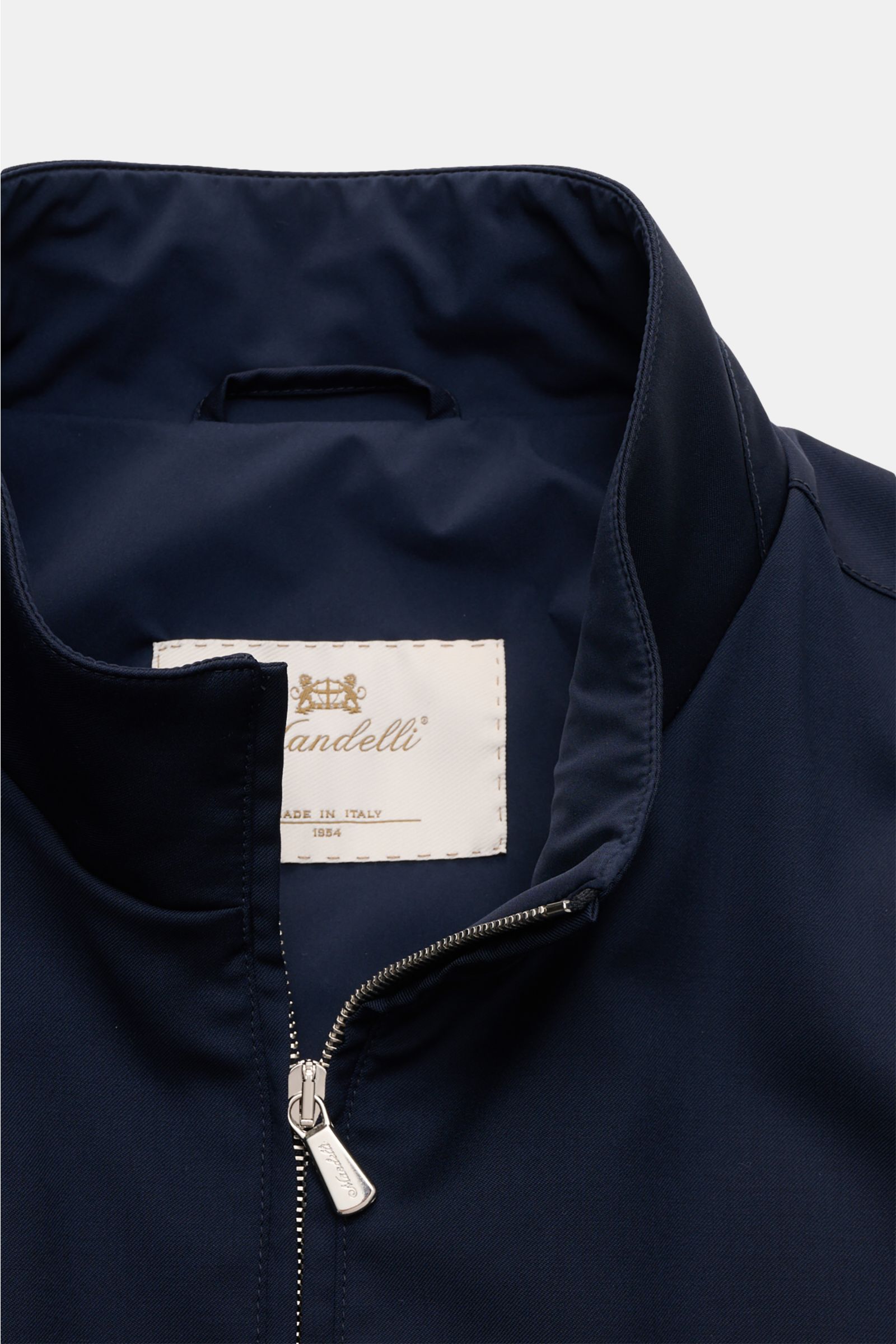 Close-up front view of the Mandelli Blouson navy showing the standing collar, two-way zip, and smooth pure wool fabric with a slim fit. Elegant ease for the transitional period: This blouson by MANDELLI combines luxurious character with a modern silhouett