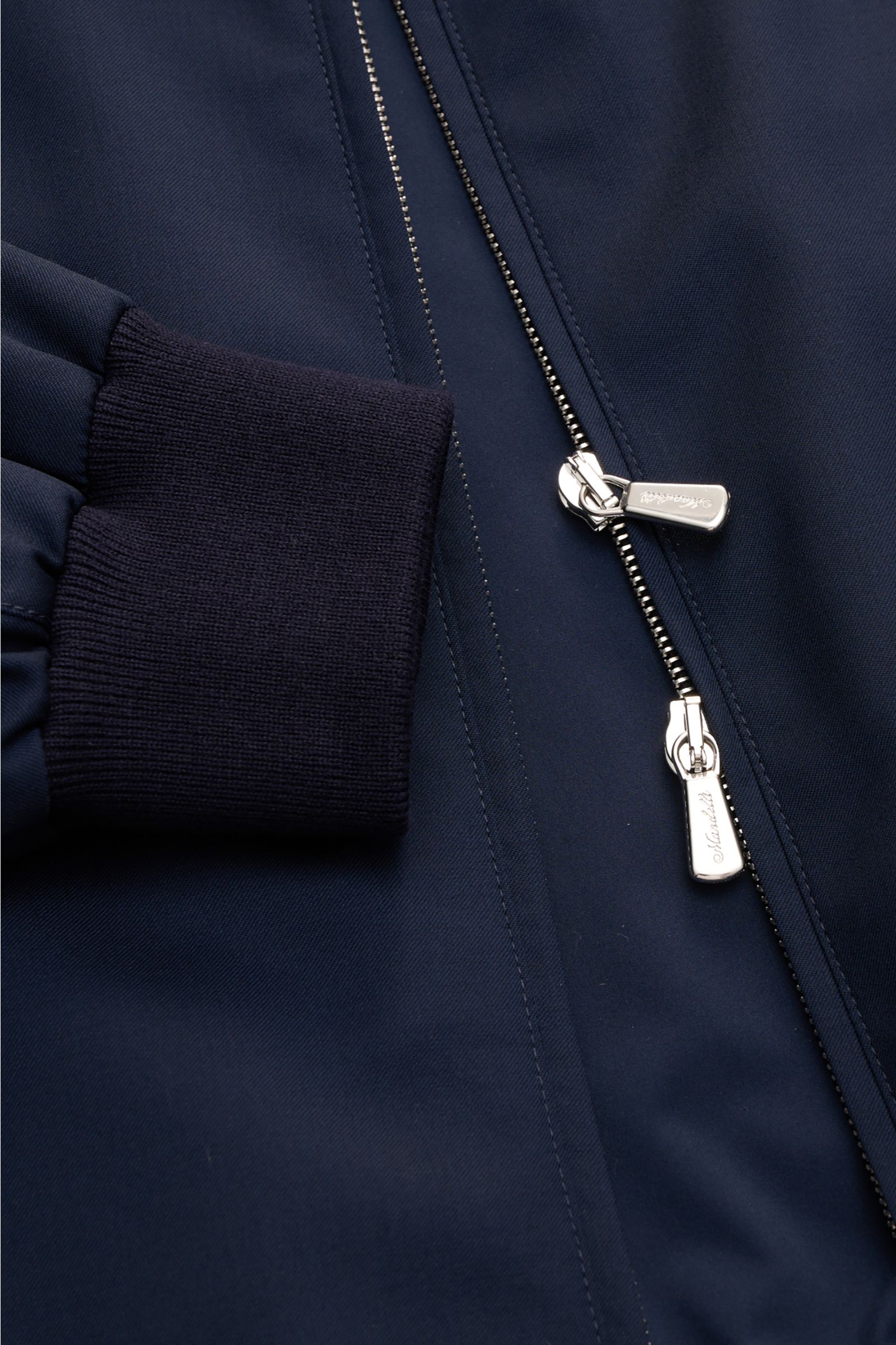 Close-up front view of the Mandelli Blouson navy showing the two-way silver zip, elastic navy sleeve cuff, and smooth pure wool fabric. Elegant ease for the transitional period: This blouson by MANDELLI combines luxurious character with a modern silhouett