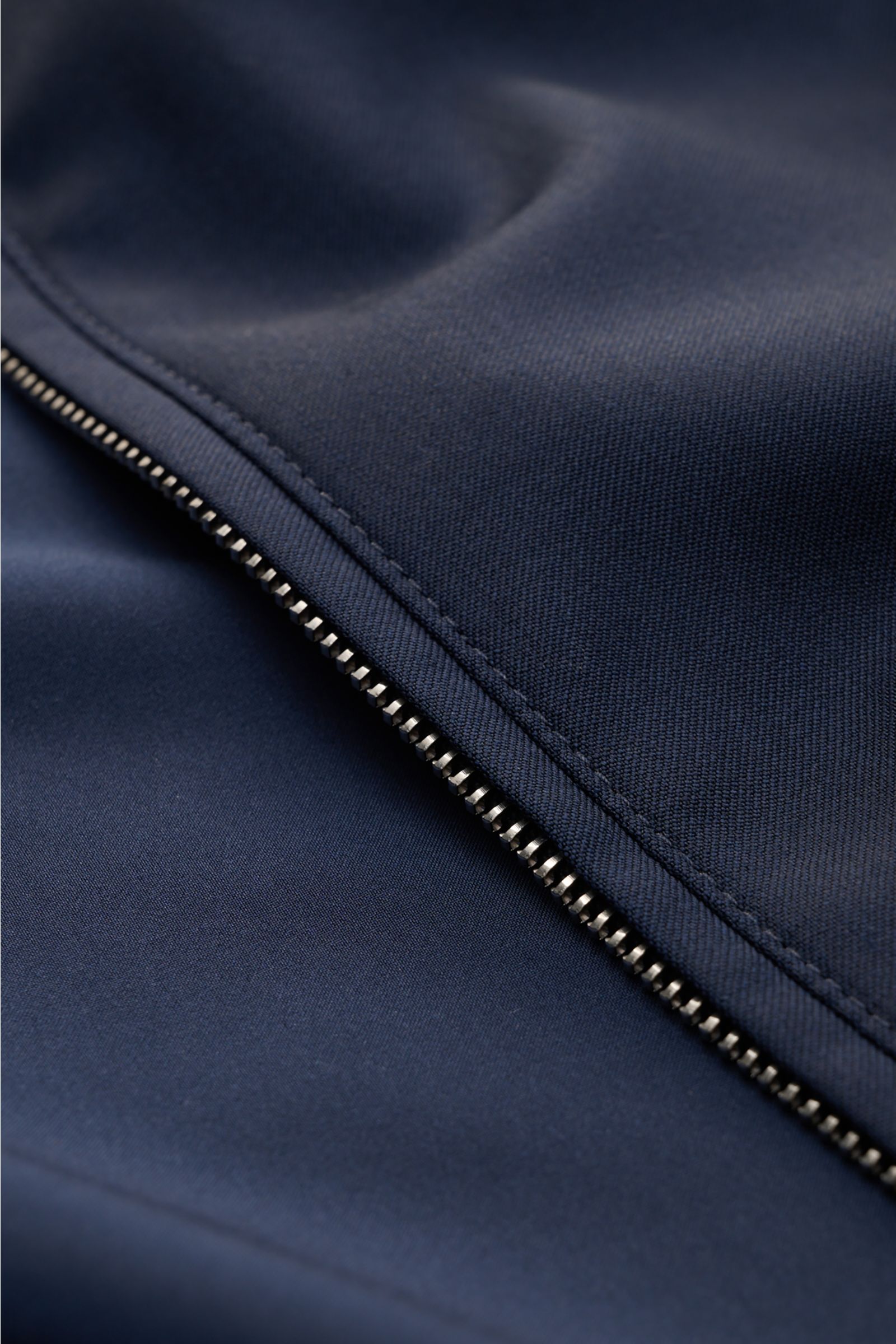 Close-up front view of the Mandelli Blouson navy showing the two-way zip, smooth pure wool fabric, and fine stitching details. Elegant ease for the transitional period: This blouson by MANDELLI combines luxurious character with a modern silhouette. Pure w