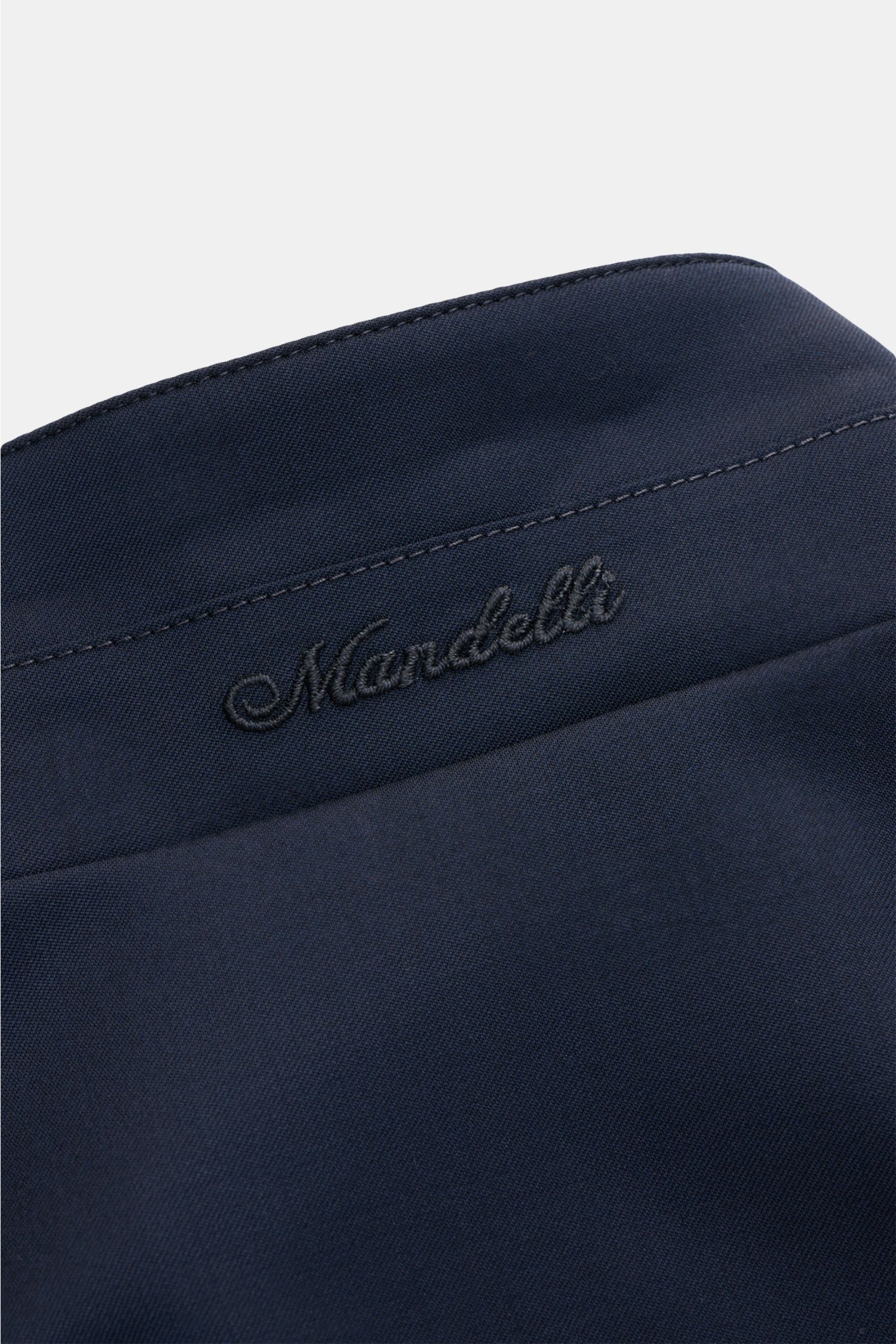 Close-up perspective of the navy Mandelli Blouson showing the standing collar with embroidered 'Mandelli' logo, smooth pure wool fabric, slim fit, two-way zip, elastic hem and sleeve cuffs, smooth lining, and three inside pockets. Elegant ease for the tra