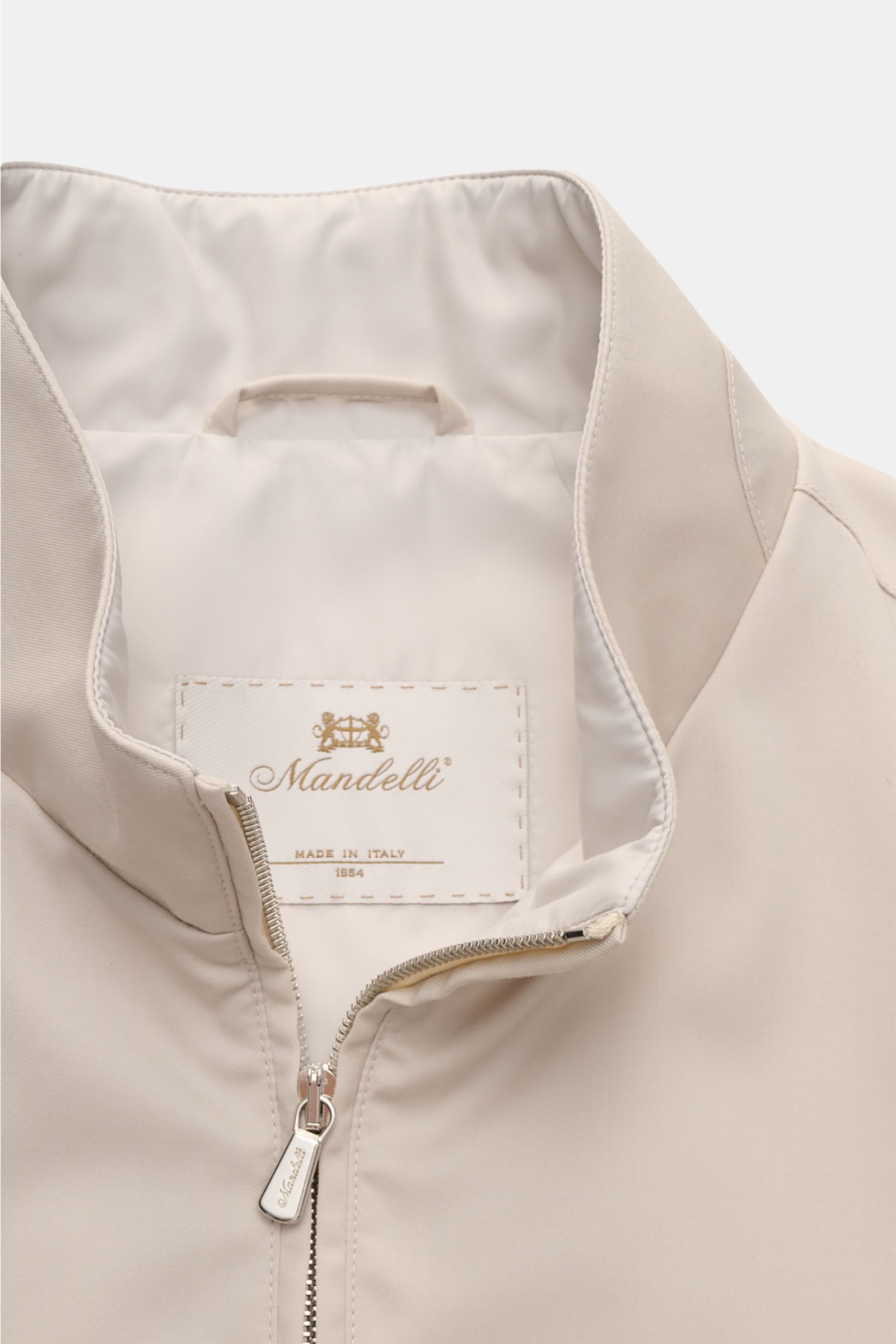 Mandelli Blouson beige mit Stehkragen und Zwei-Wege-Reißverschluss, glattem Griff, Slim Fit, elastischen Bündchen, Innenfutter und drei Innentaschen, Nahaufnahme von oben.