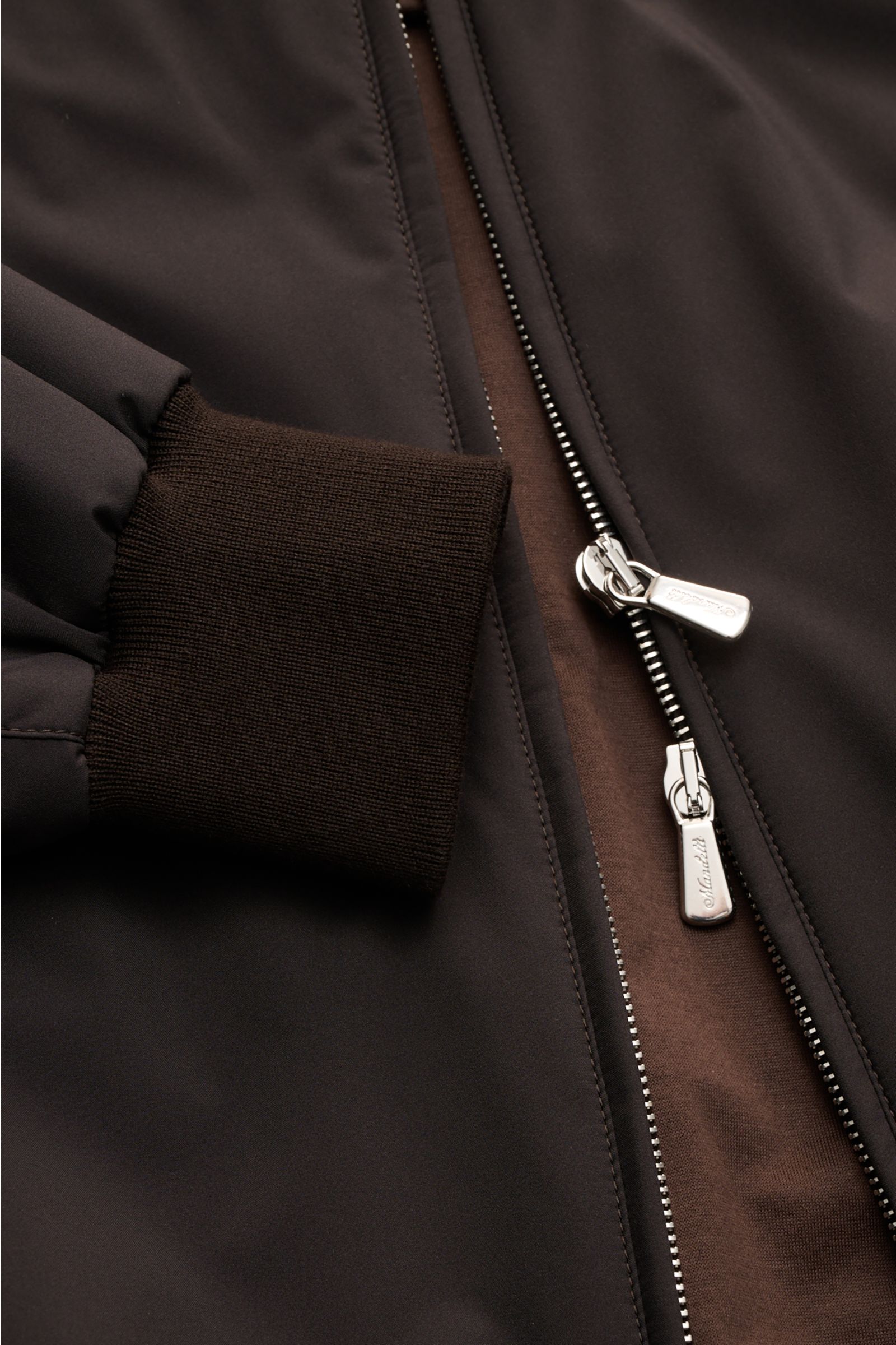 Close-up front view of the Mandelli Blouson dark brown showing the slim fit, high-closing standing collar, robust two-way silver zipper, and wide ribbed cuff on the sleeve. A perfect symbiosis of luxury and comfort: This blouson by MANDELLI is confidently