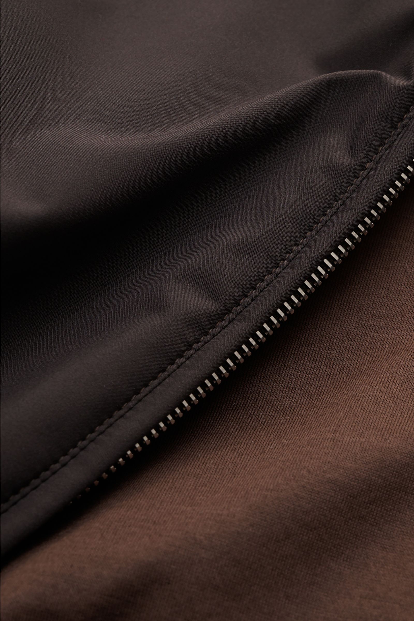 Close-up from above of the Mandelli Blouson dark brown showing the high-quality microfibre, goat suede trim, and robust two-way zip. A perfect symbiosis of luxury and comfort: This blouson by MANDELLI is confidently elegant and effortlessly enhances your 