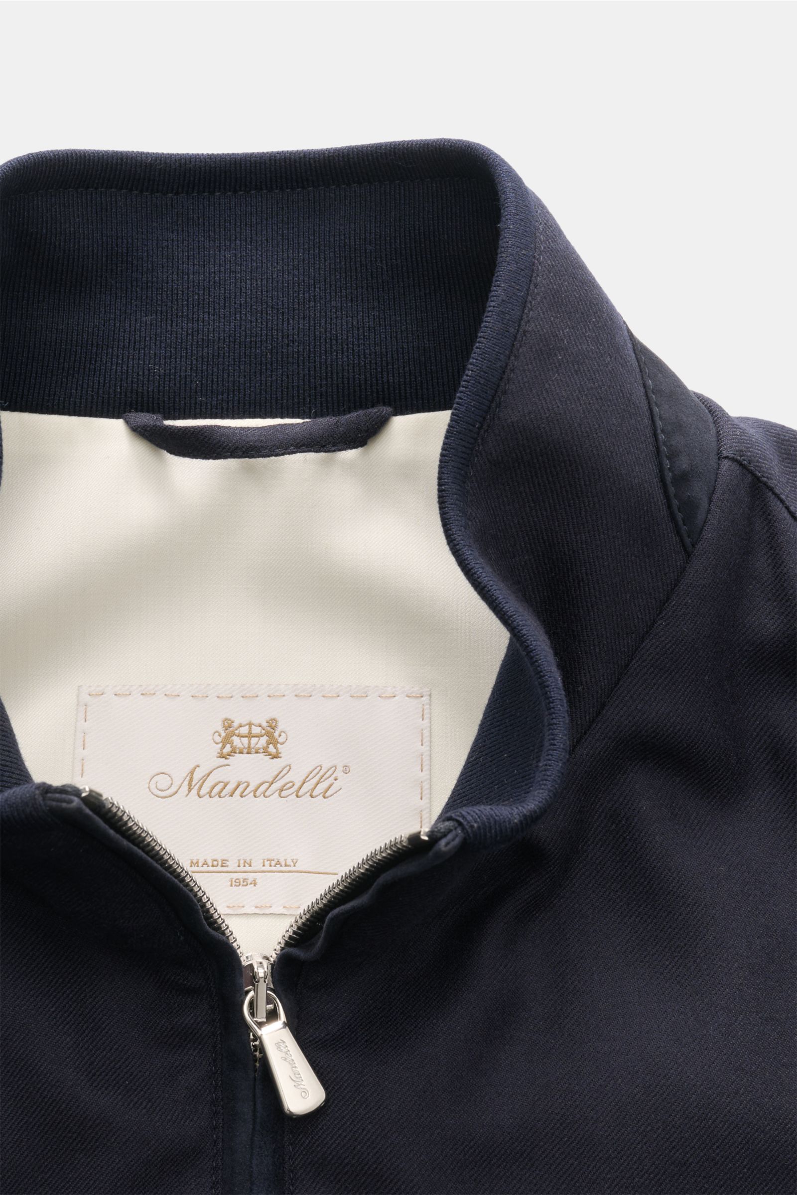 Close-up front view of the Mandelli Cashmere blouson navy showing the standing collar, two-way zip, and inner label. Exquisite ease for the transitional period: This fine cashmere blouson by MANDELLI is timelessly elegant with a luxurious character. Pure 