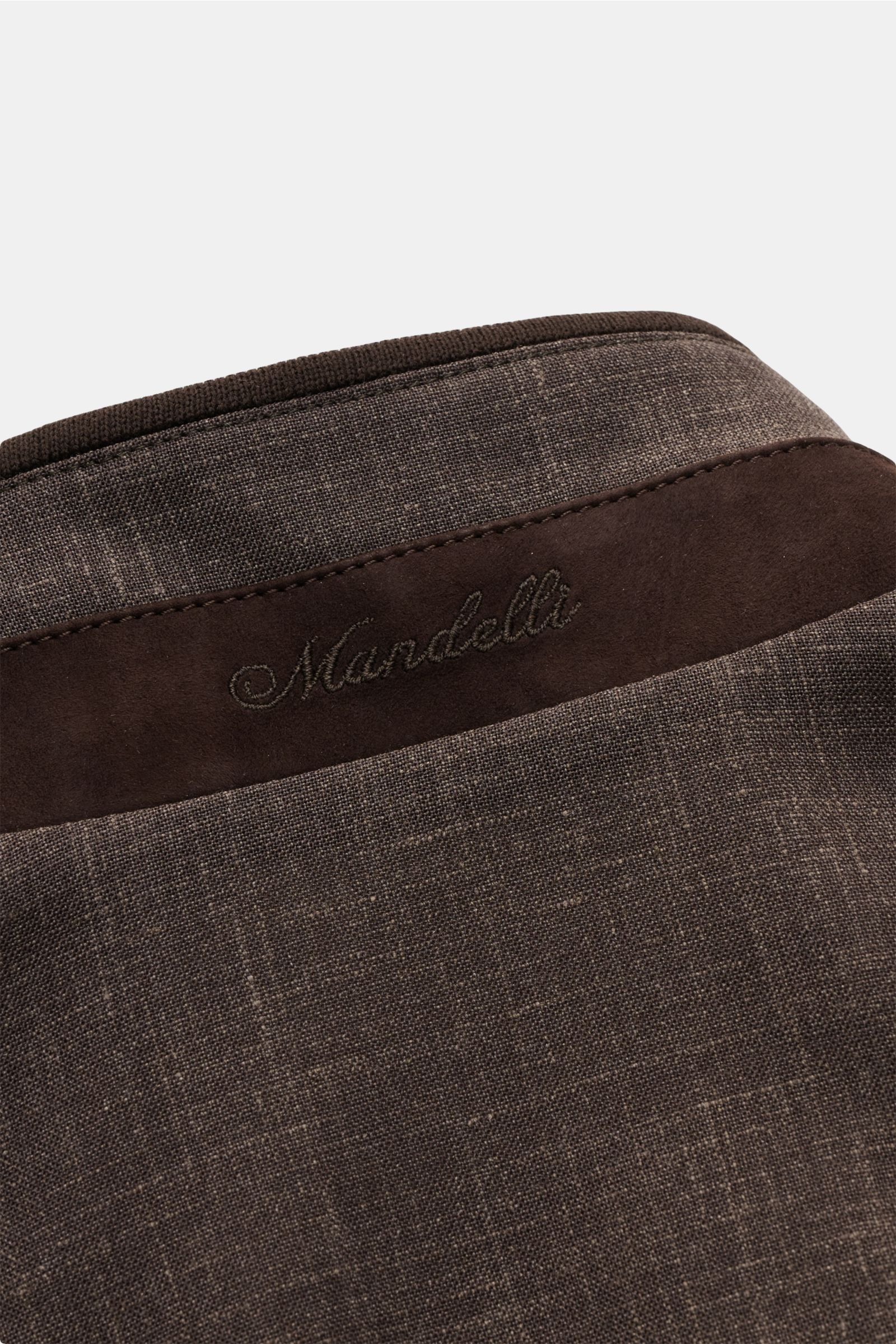 Nahaufnahme des graubraun melierten Mandelli Blousons von hinten oben, zeigt Stehkragen mit braunem Besatz und Sticklogo.