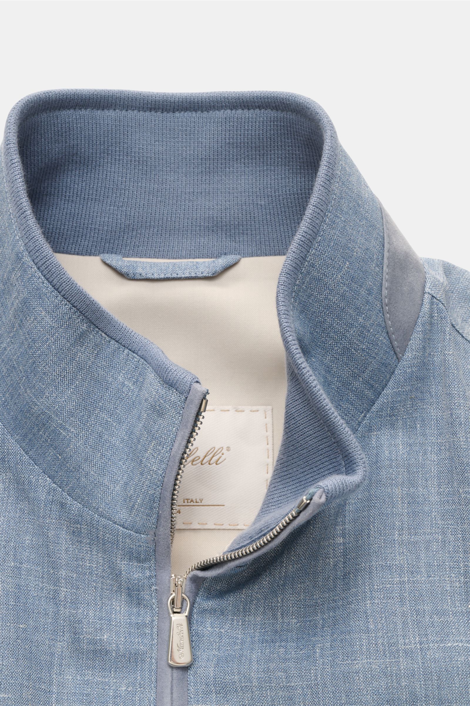 Close-up front view of the Mandelli Blouson smoky blue mottled showing its standing collar, two-way zip, and textured fabric. Confident ease for the transitional period: Its luxurious character makes this blouson by MANDELLI an essential piece for spring.