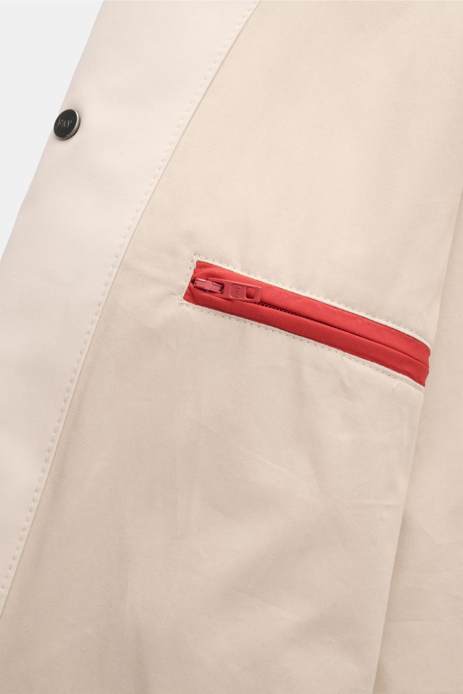 Close-up of Fay Blouson beige showing a slanted hip pocket with a red zipper and a black snap button, photographed from the front side. A luxurious all-rounder for the transitional period: This blouson by FAY effortlessly enhances sophisticated leisure lo