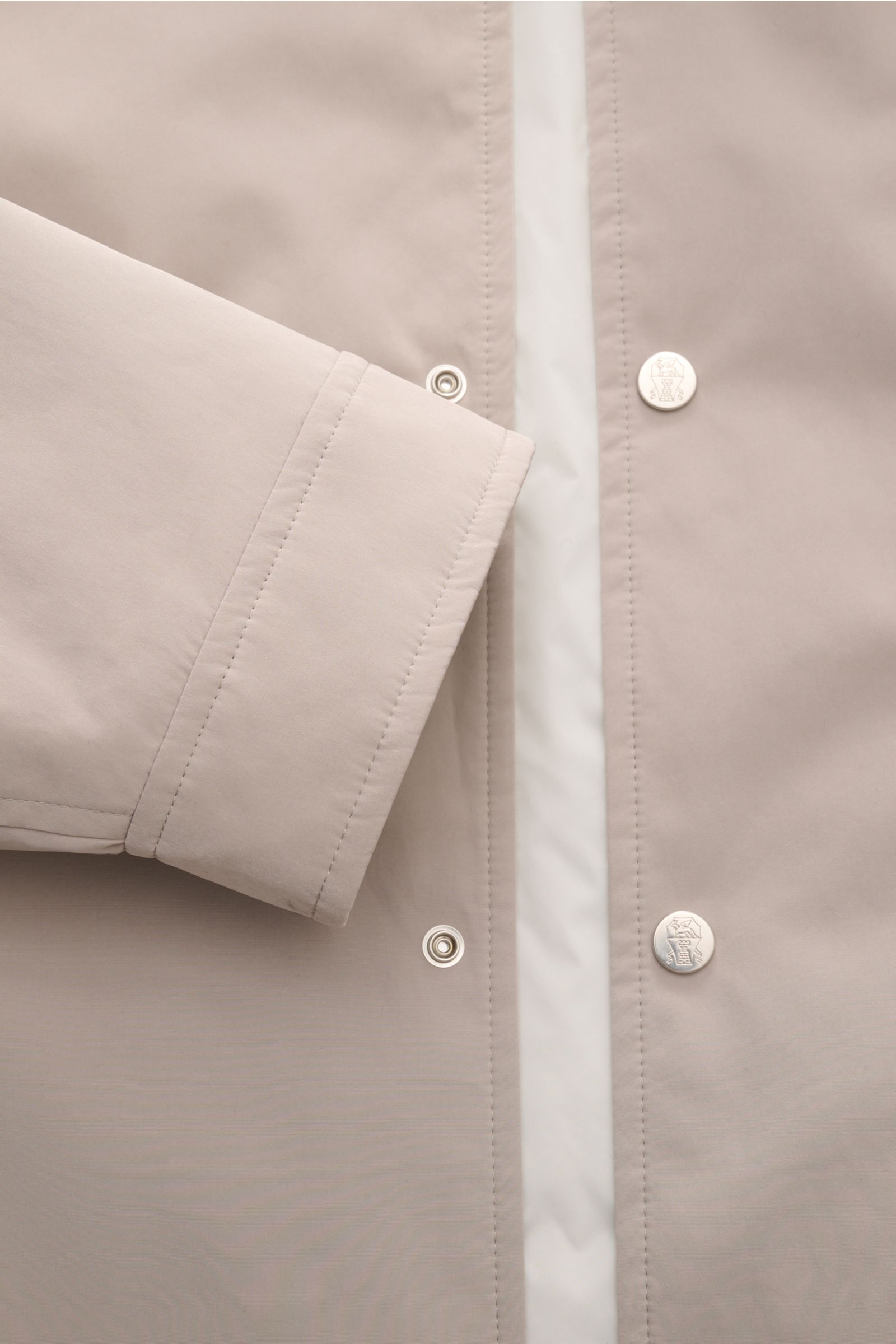 Close-up front view of Brunello Cucinelli Jacke sand showing soft microfiber fabric, snap button placket, and detailed cuff stitching.