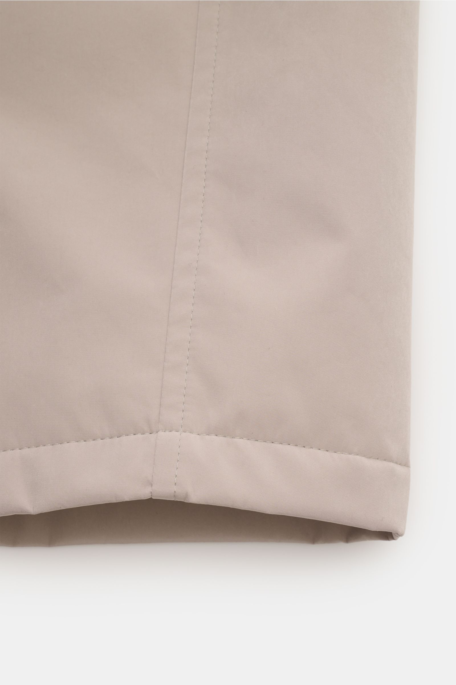 Close-up view of the lower hem of the Brunello Cucinelli Jacke sand, showcasing its high-quality microfiber, smooth texture, and precise stitching. Feinster Komfort trifft auf moderne Funktion: Diese Jacke von BRUNELLO CUCINELLI überzeugt mit hochwertiger