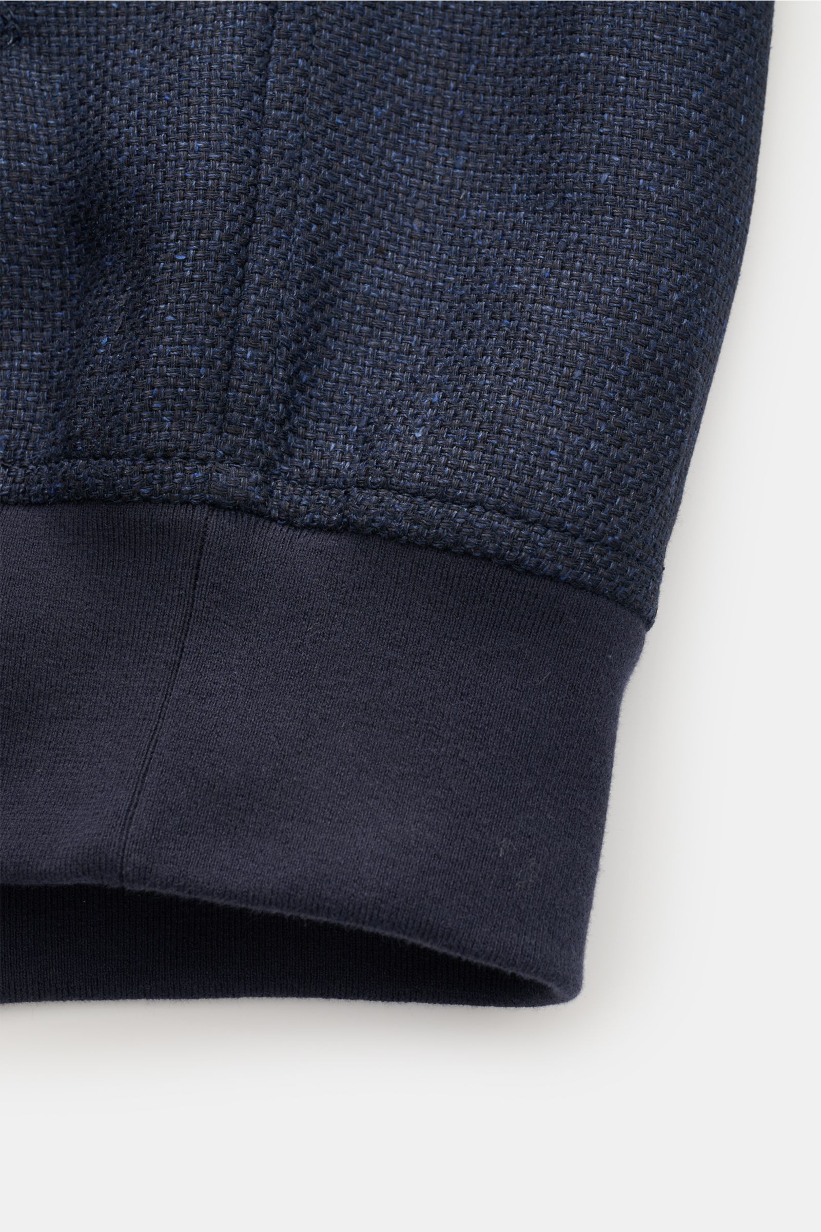 Close-up front view of the elasticated hem and distinctive three-dimensional weave of the Brunello Cucinelli Blouson navy mottled, made of a silk, linen, and wool blend.
